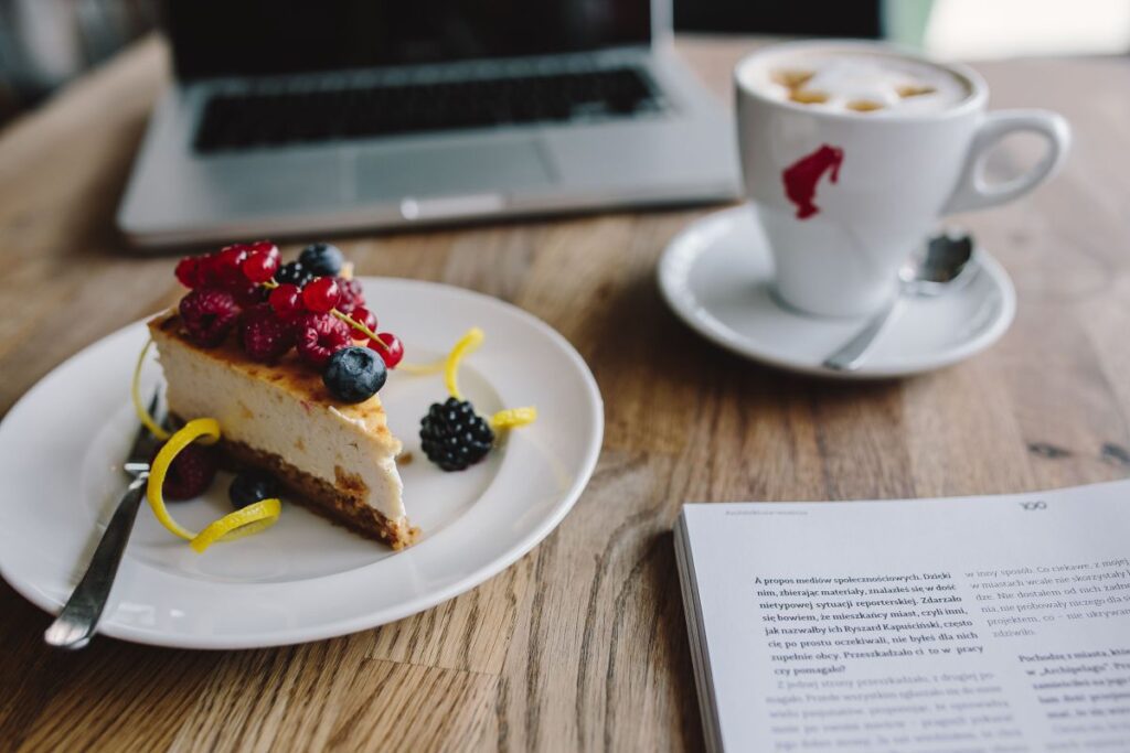 Working in a restaurant: Macbook, Cheese Cake and Cup of Coffee Stock Free