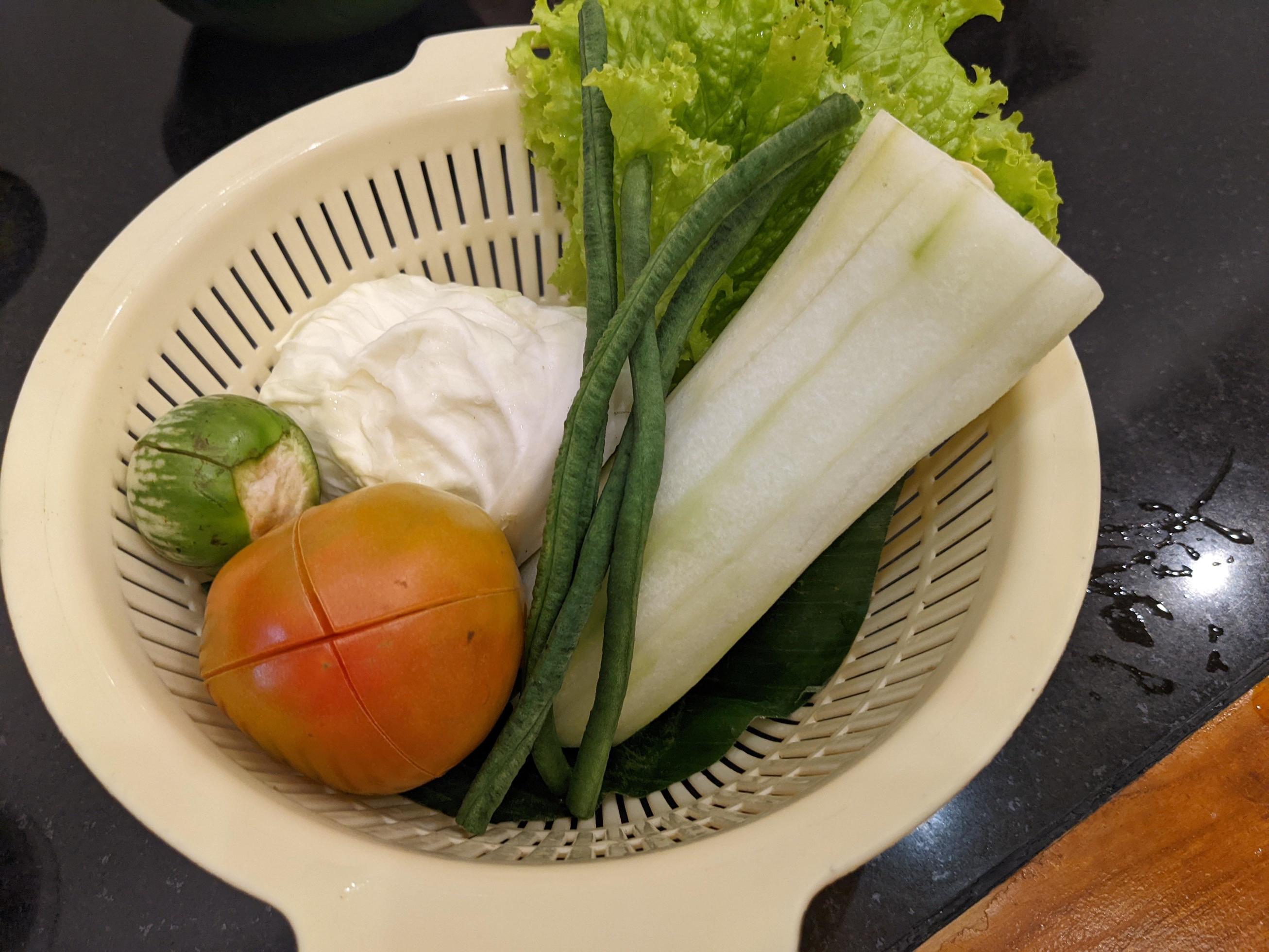 Close up photo of salad on the white basket, tomato, eggplant and cabbage. The photo is suitable to use for vegan food background, poster and food content. Stock Free