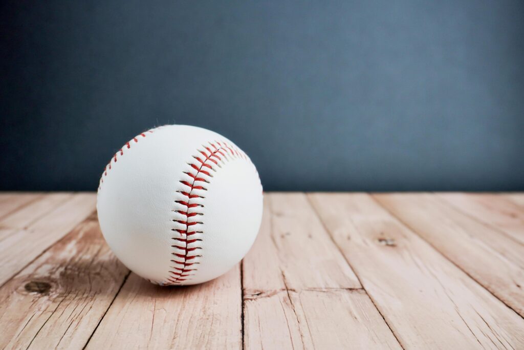 White and red colored baseball curveball equipment. Object photography isolated on horizontal ratio wooden surface background. Stock Free