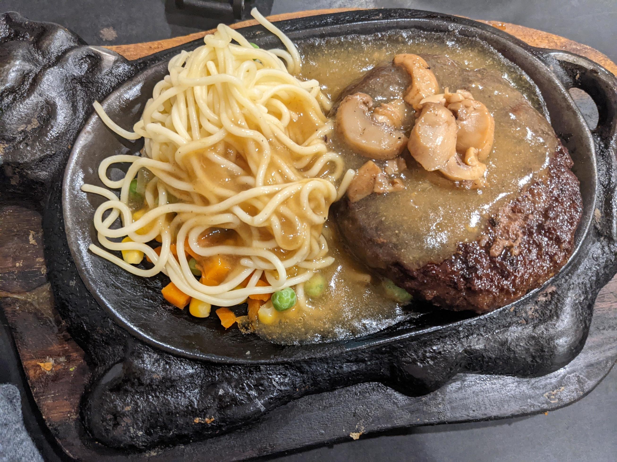 Extra beef steak with noodles and mushroom sauce. The photo is suitable to use for food background, poster and food content media. Stock Free