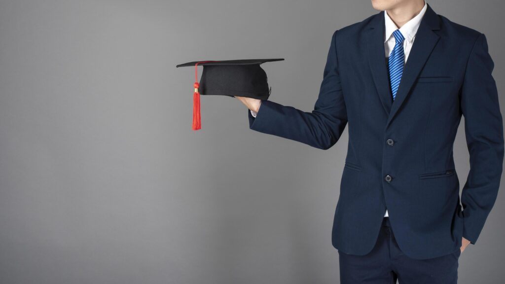 business man is holding graduation hat, business education concept Stock Free