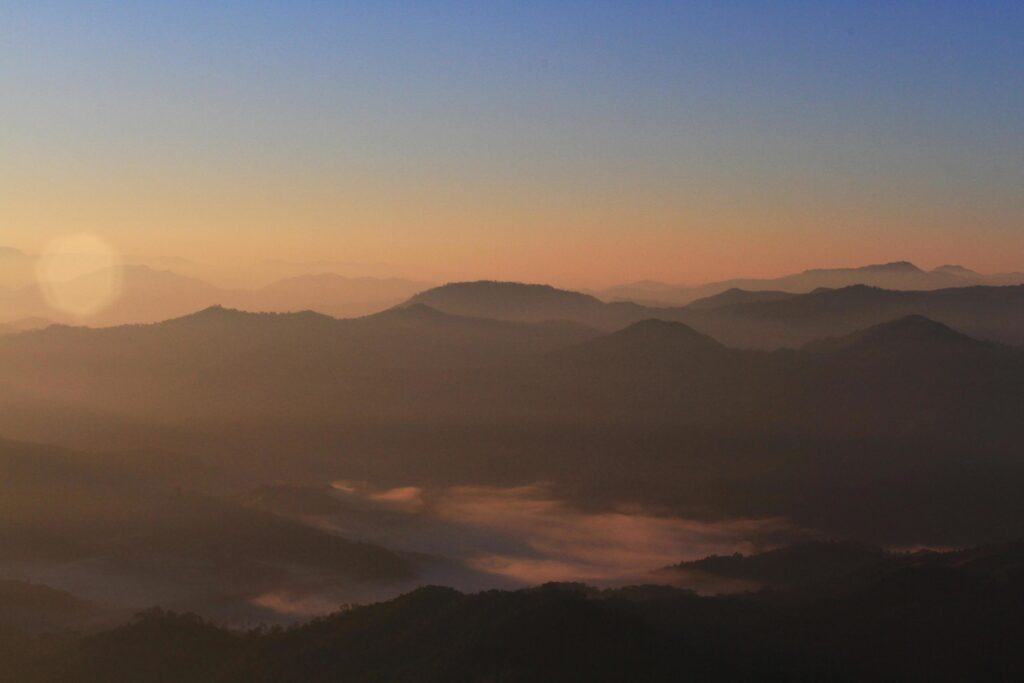 Beautiful golden natural sunlight and twiligh of sunrise shining to in the mist on valley of mountain in Thailand Stock Free