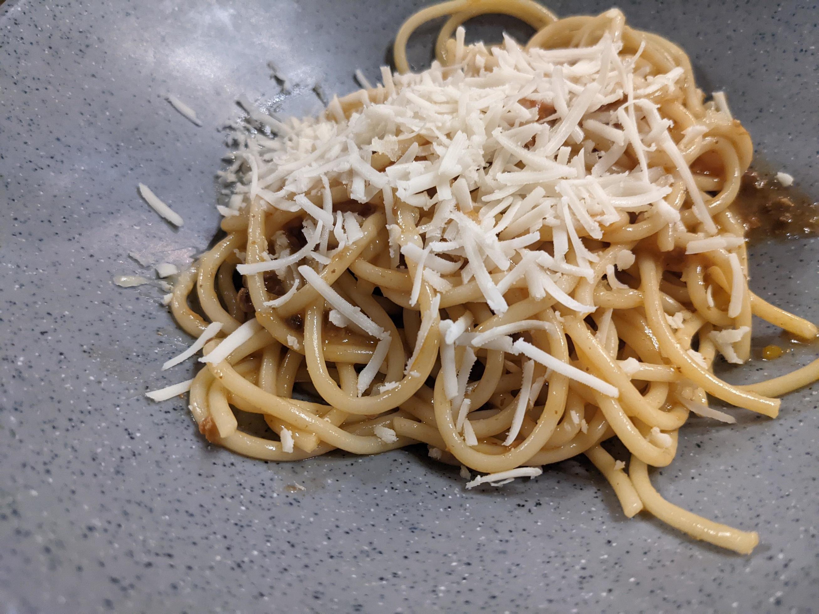 Spaghettis Bolognese with cheese cheddar topping on the grey bowl. The photo is suitable to use for food background, poster and food content. Stock Free