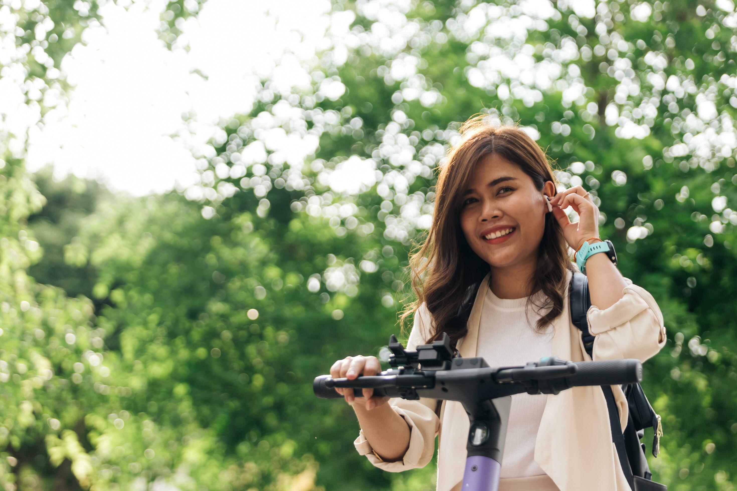 Happy young asian woman riding a bicycle in the park. Healthy lifestyle concept. Stock Free