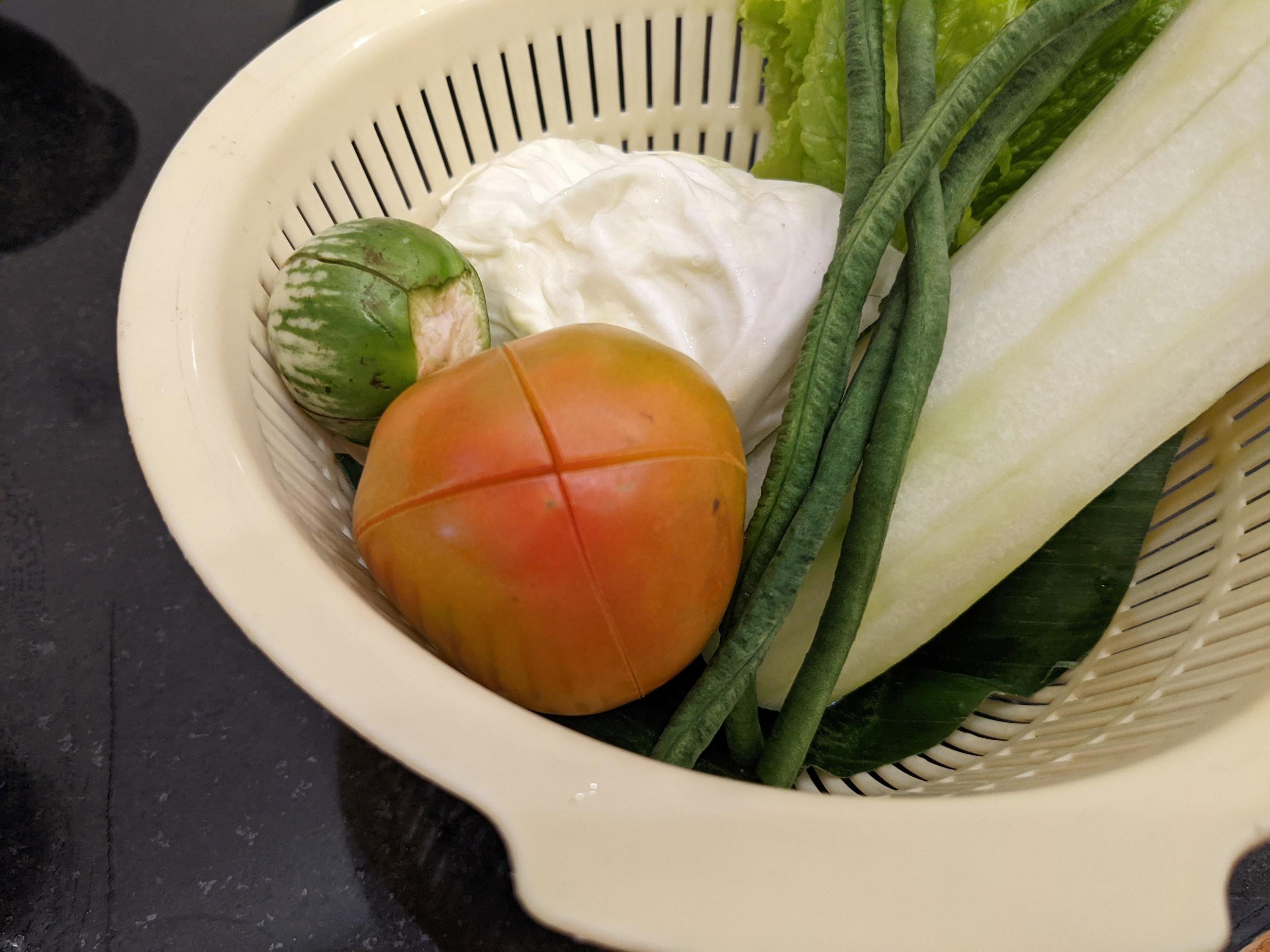 Close up photo of salad on the white basket, tomato, eggplant and cabbage. The photo is suitable to use for vegan food background, poster and food content. Stock Free