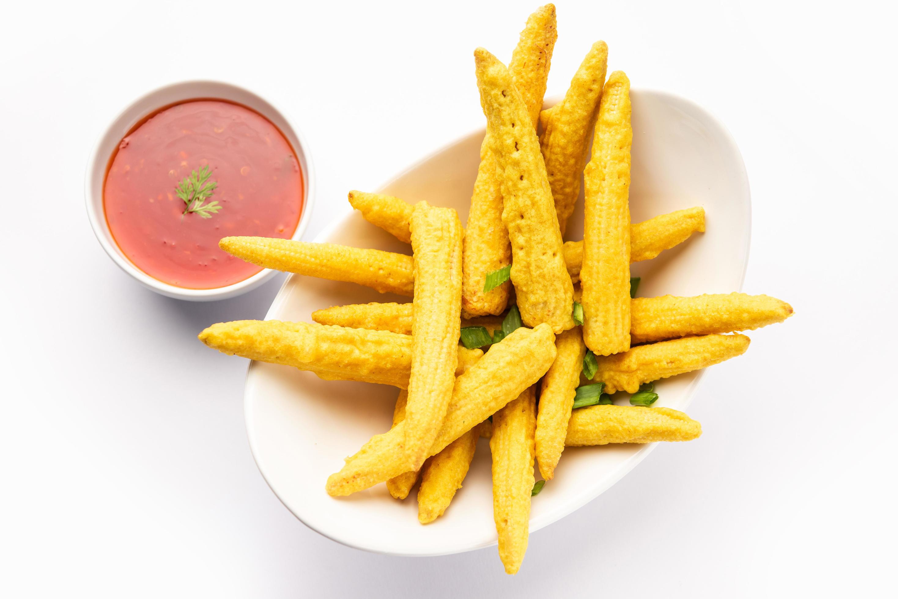 Crispy fried baby corn pakoda, pakora or Baby corn fritters served with ketchup, Indian food Stock Free