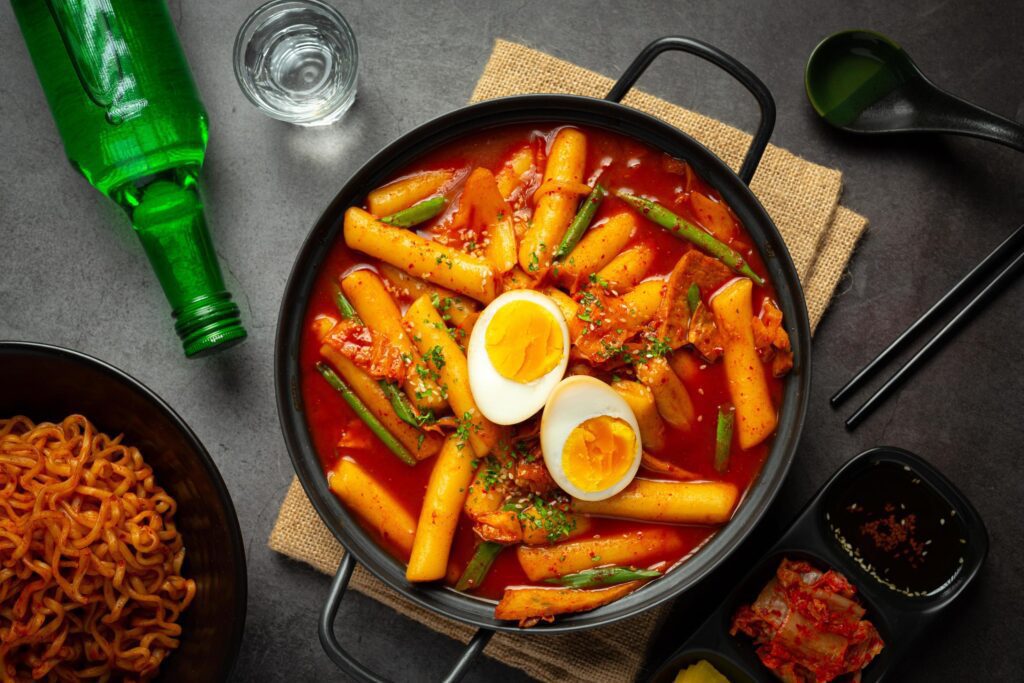 Cheesy Tokbokki korean traditional food on black board background. Lunch dish. Stock Free