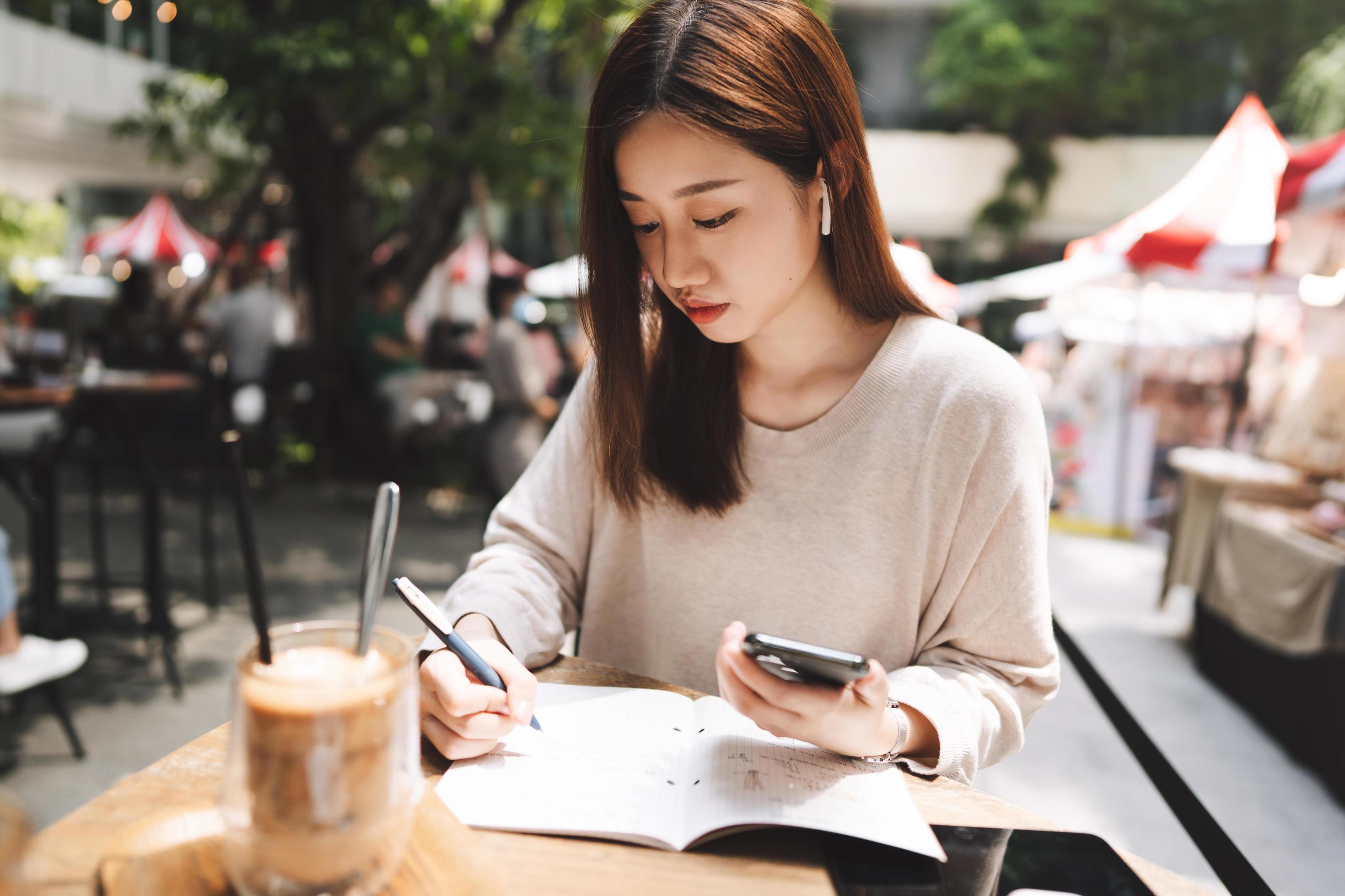 Young adult business asian woman writing note book with gadget technology lifestyle Stock Free