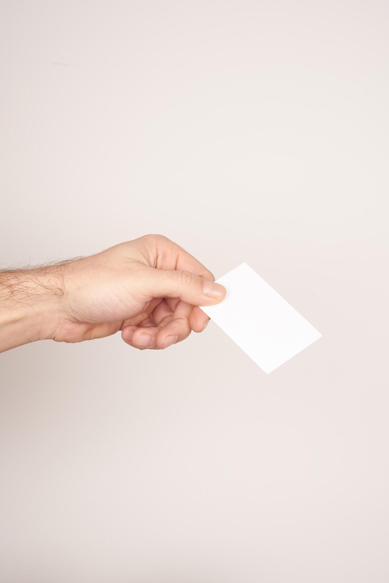 Male hand holding and giving a white blank business card Stock Free