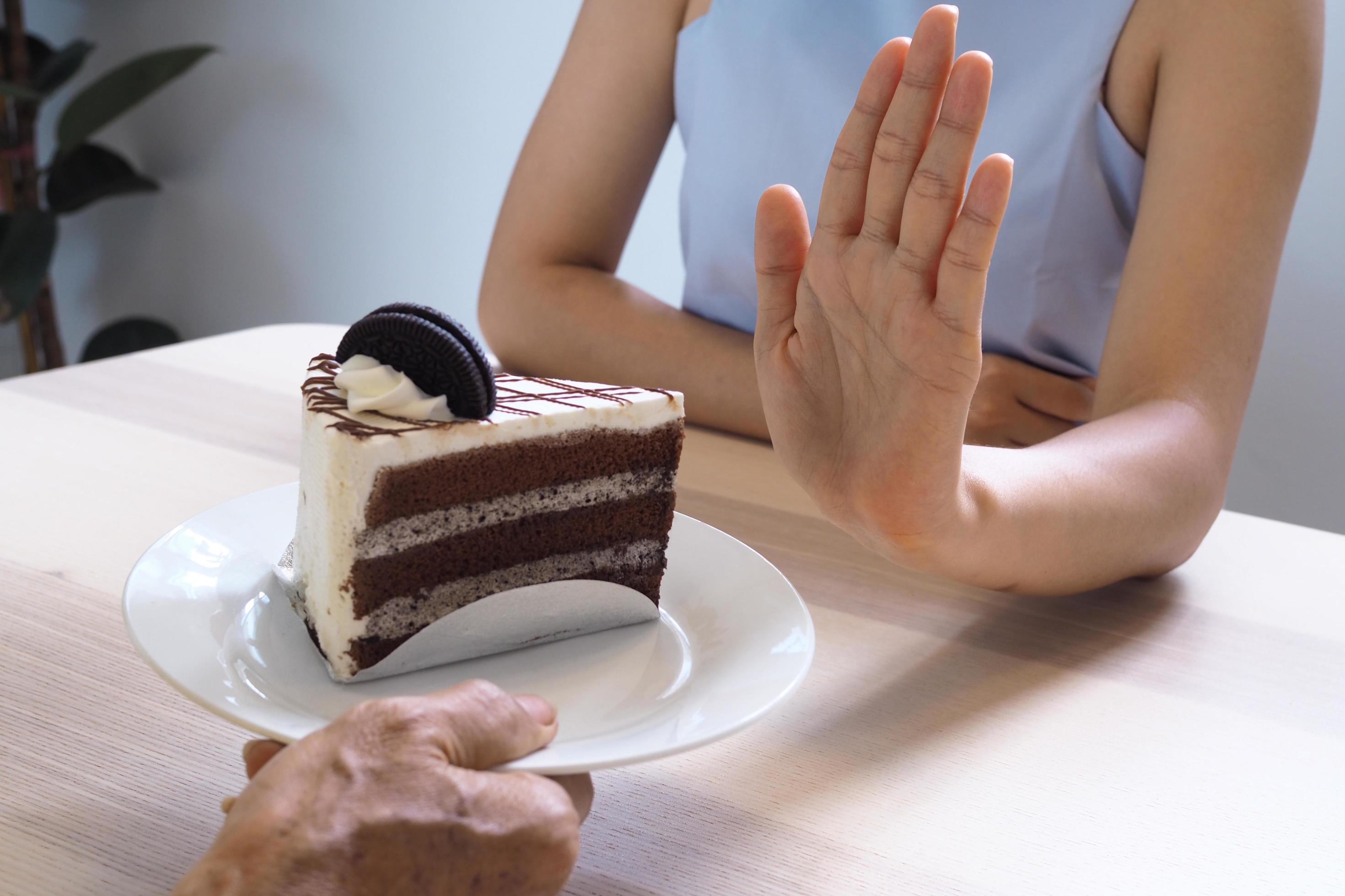 One of the health-care girls used a hand to push a plate of chocolate cake. Refuse to eat foods that contain Trans Fat. Stock Free