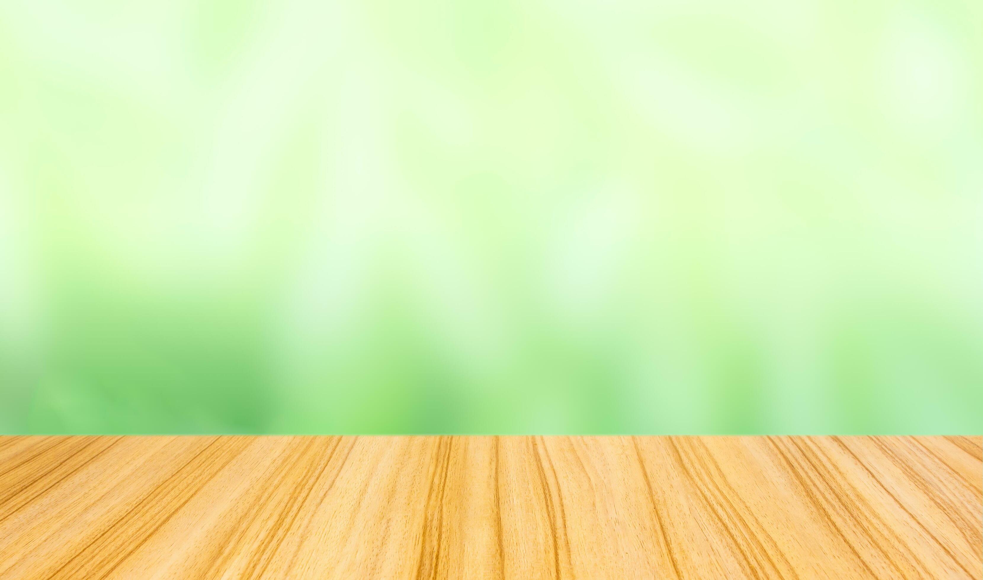 perspective wood table top on blur abstract green background Stock Free