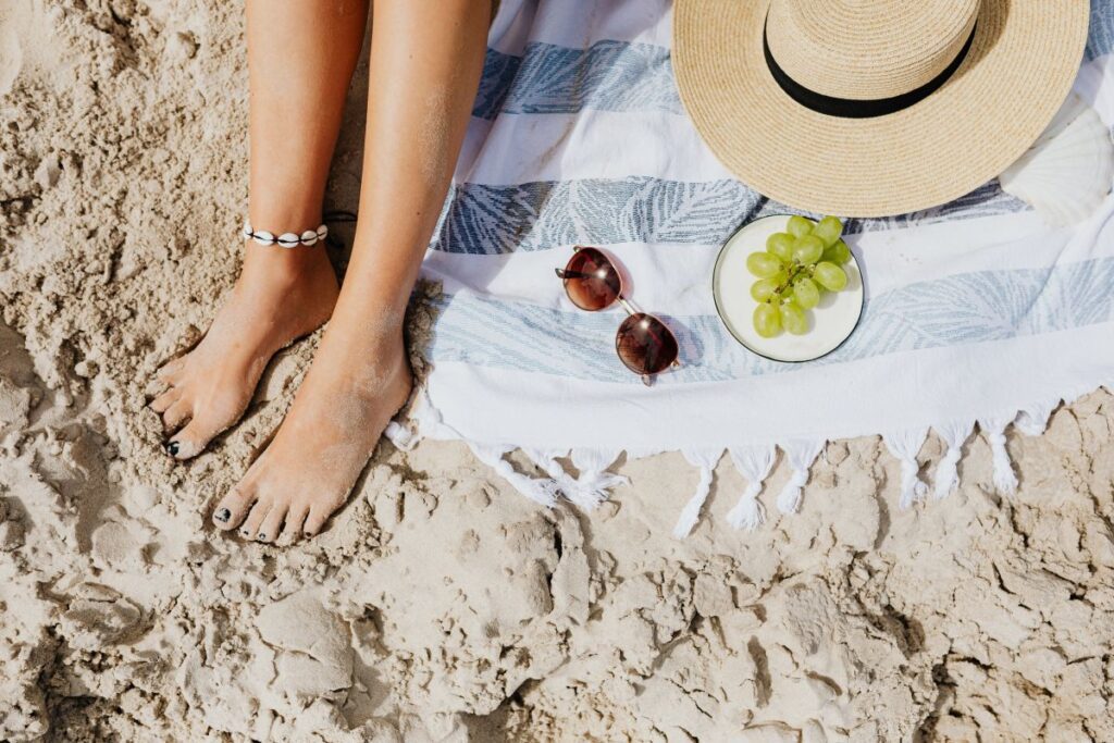 A woman reads on the beach in the summer Stock Free