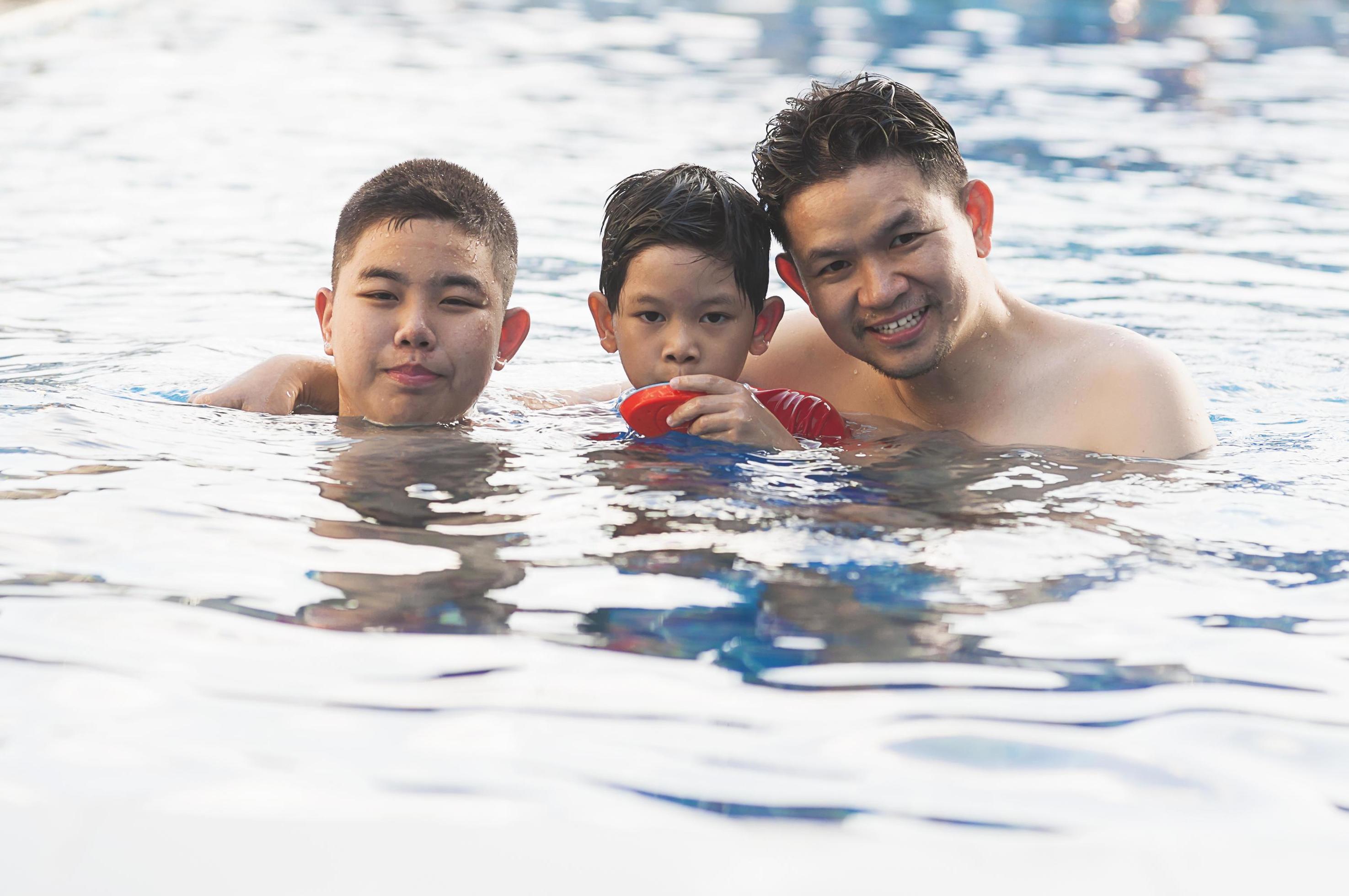 Happy dad and son swimming in a pool Stock Free