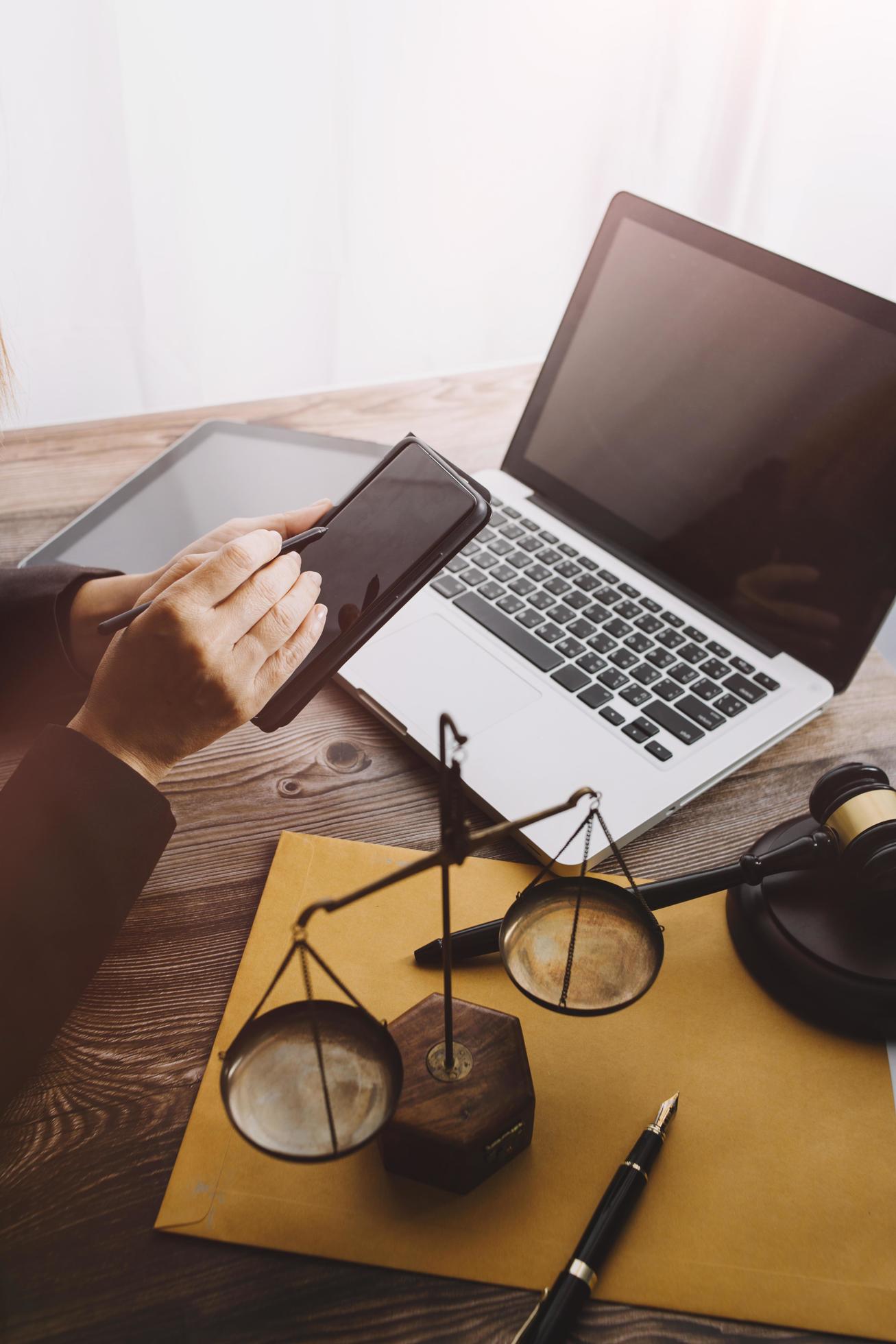 Justice and law concept.Male judge in a courtroom with the gavel, working with, computer and docking keyboard, eyeglasses, on table in morning light Stock Free