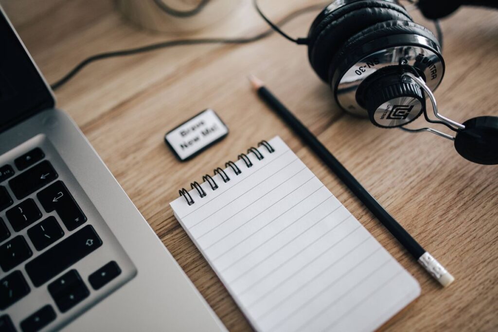 MacBook Pro with headphones on a wooden desk Stock Free