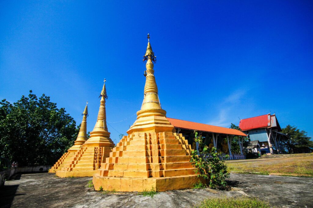 Golden pagoda detail is Mon architectural style at temple located in Kanchanaburi Province, Thailand. Stock Free