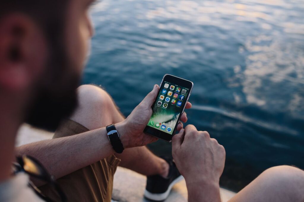 Mobile phone in man’s hands near the sea Stock Free