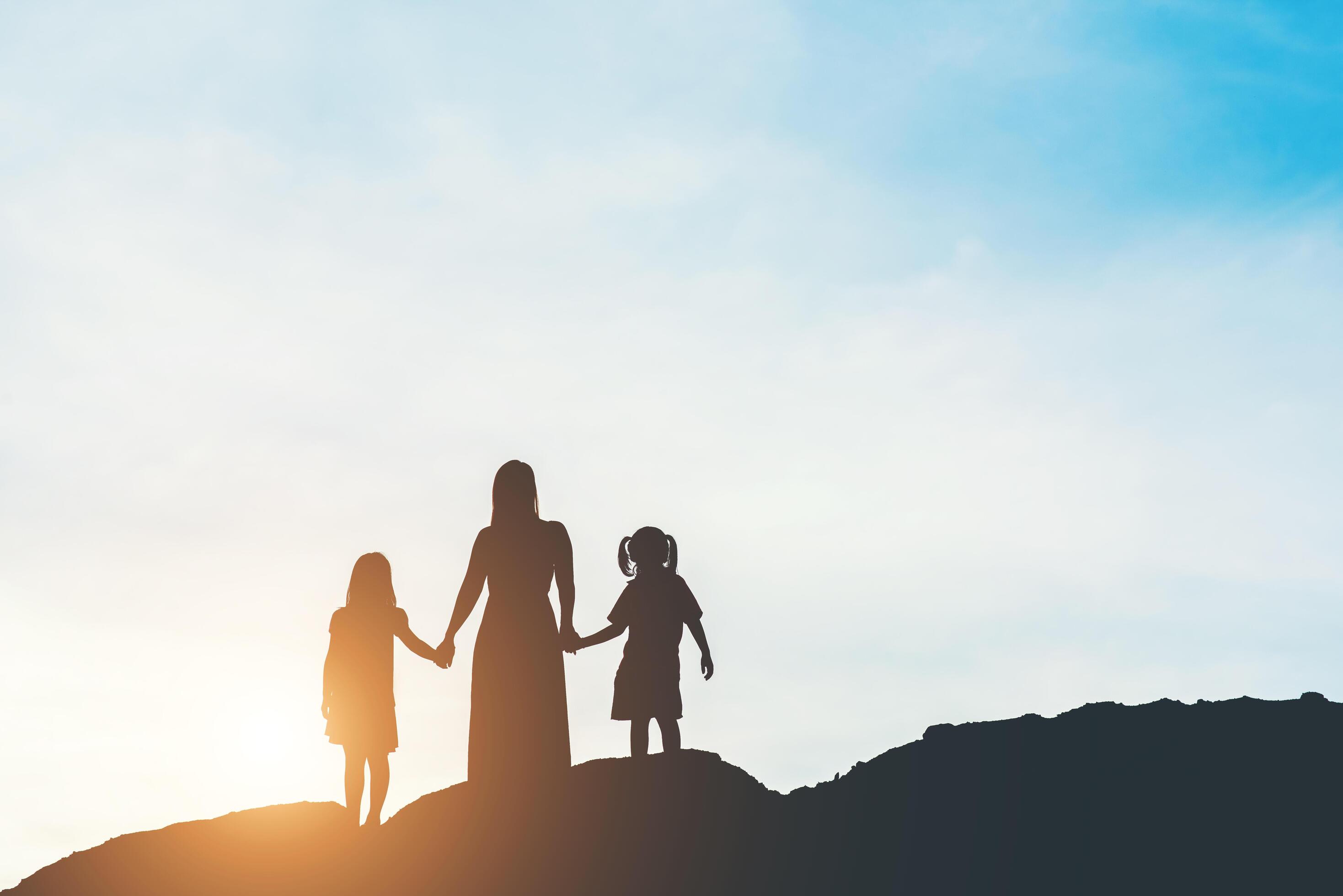 Silhouette of mother with her daughter standing and sunset Stock Free