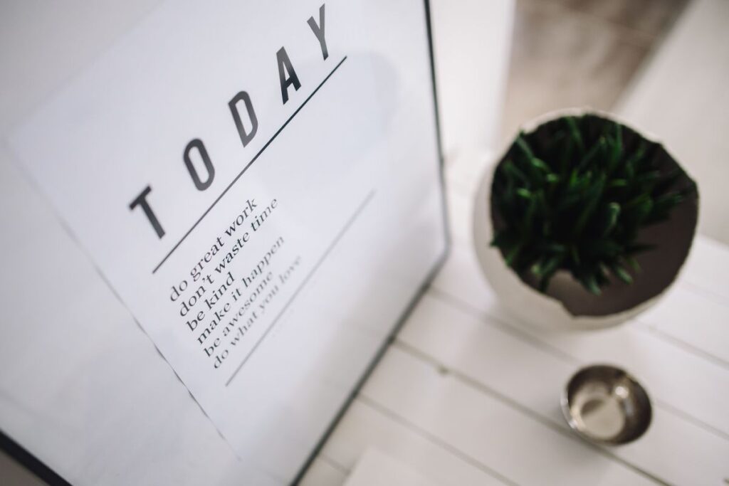 Small wooden table with a potted plant and a grey wallet Stock Free