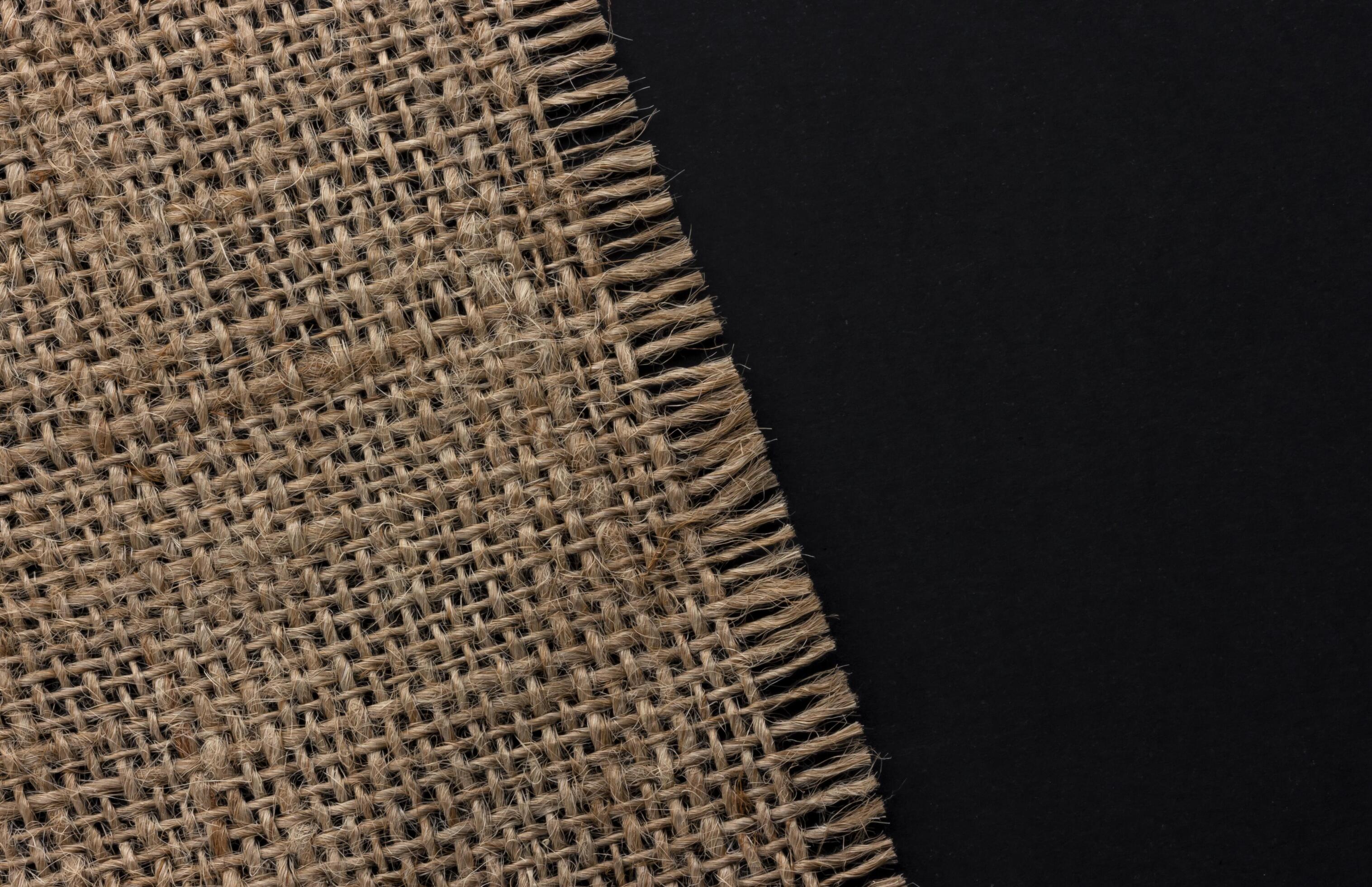 Old burlap fabric napkin on black background, top view Stock Free