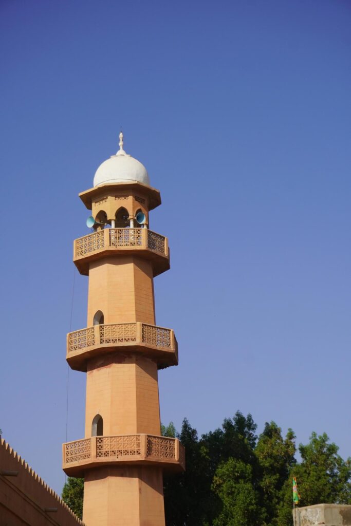 A tower with a white dome and a blue sky Stock Free