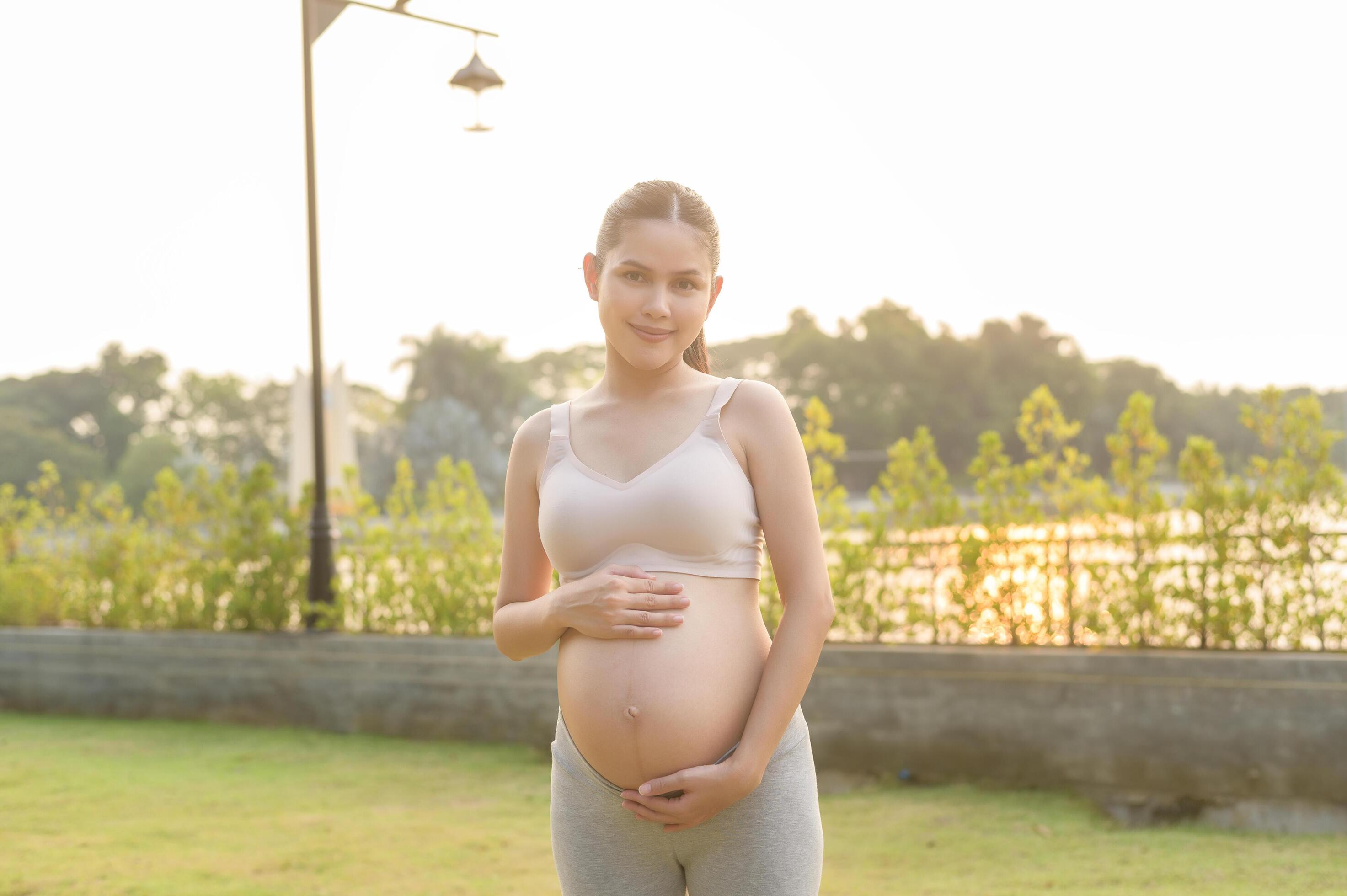 Portrait of Beautiful pregnant woman in the park, Healthy and active pregnancy lifestyle concept. Stock Free