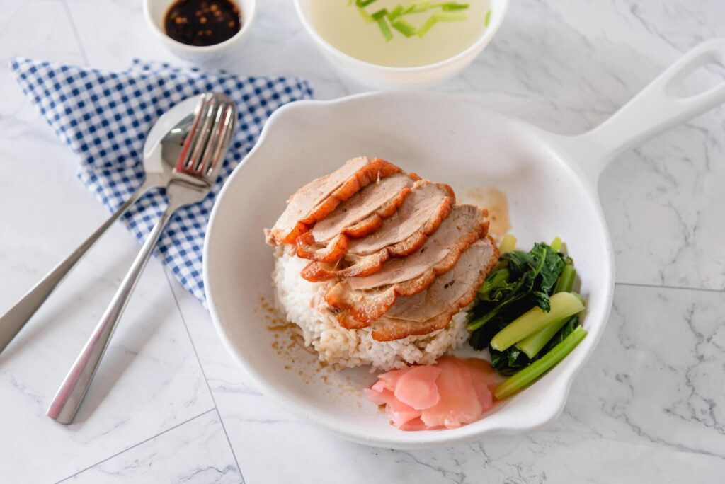 Roasted duck with steam rice, vegetable and pickled ginger on white background as traditional Chinese food Stock Free