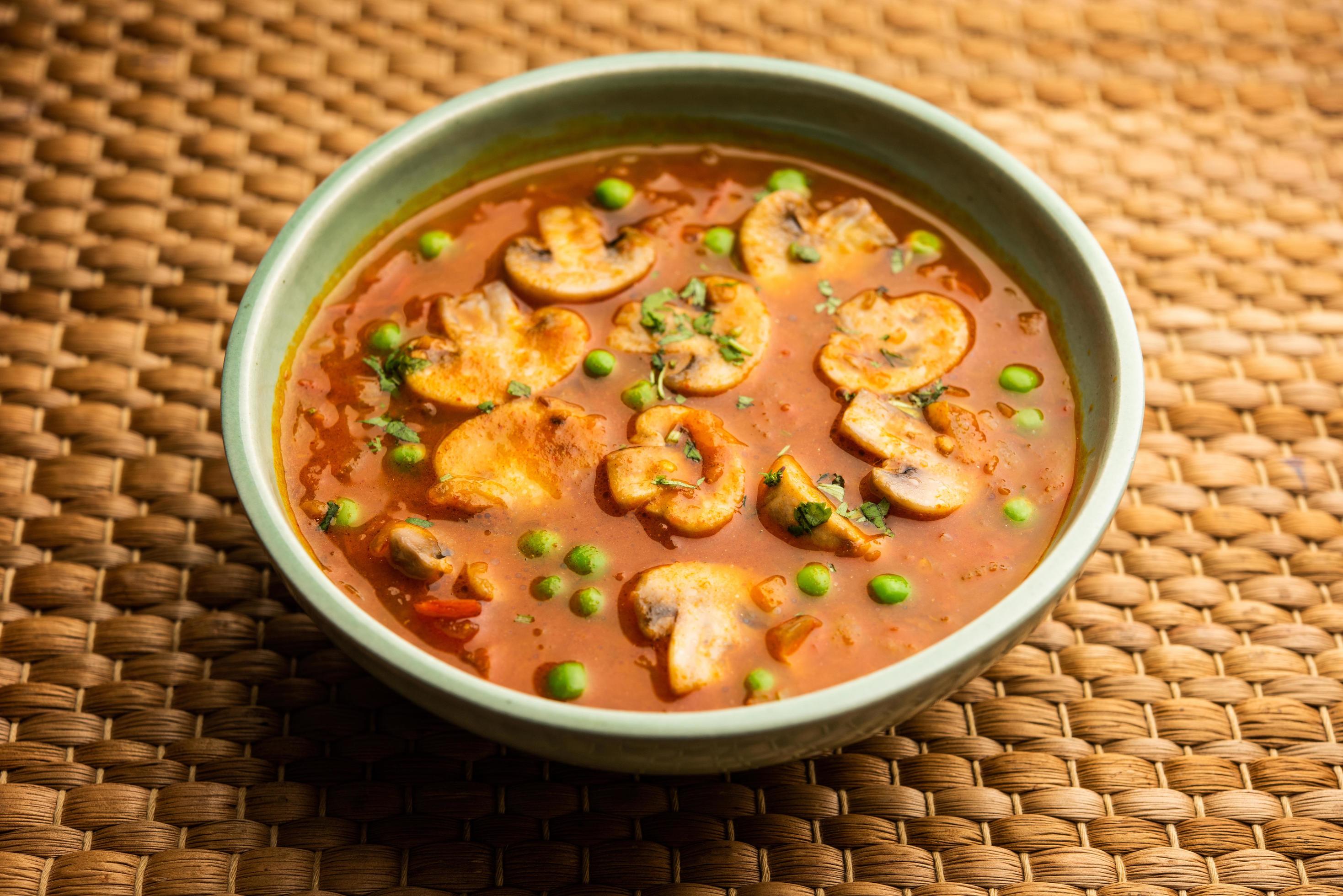 Mushroom and Pea Curry with Roasted Garlic, Indian food served in a bowl Stock Free