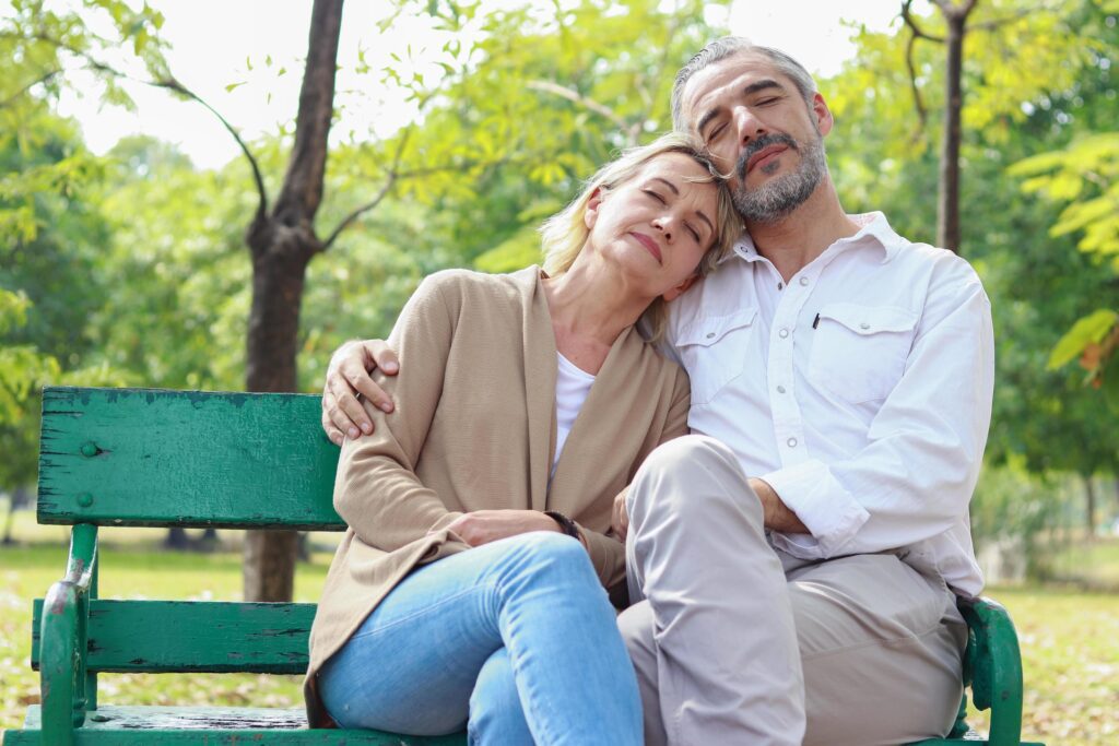 Couple relaxing on park bench Stock Free