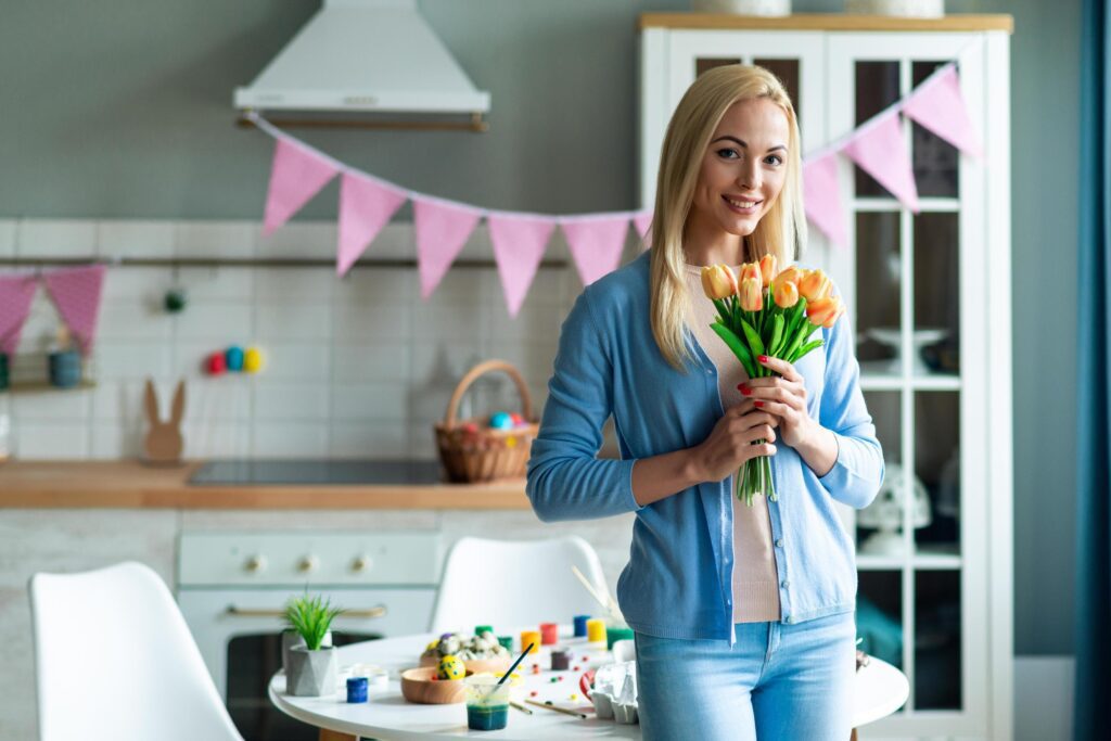 Woman holding flowers in decorated kitchen. Stock Free