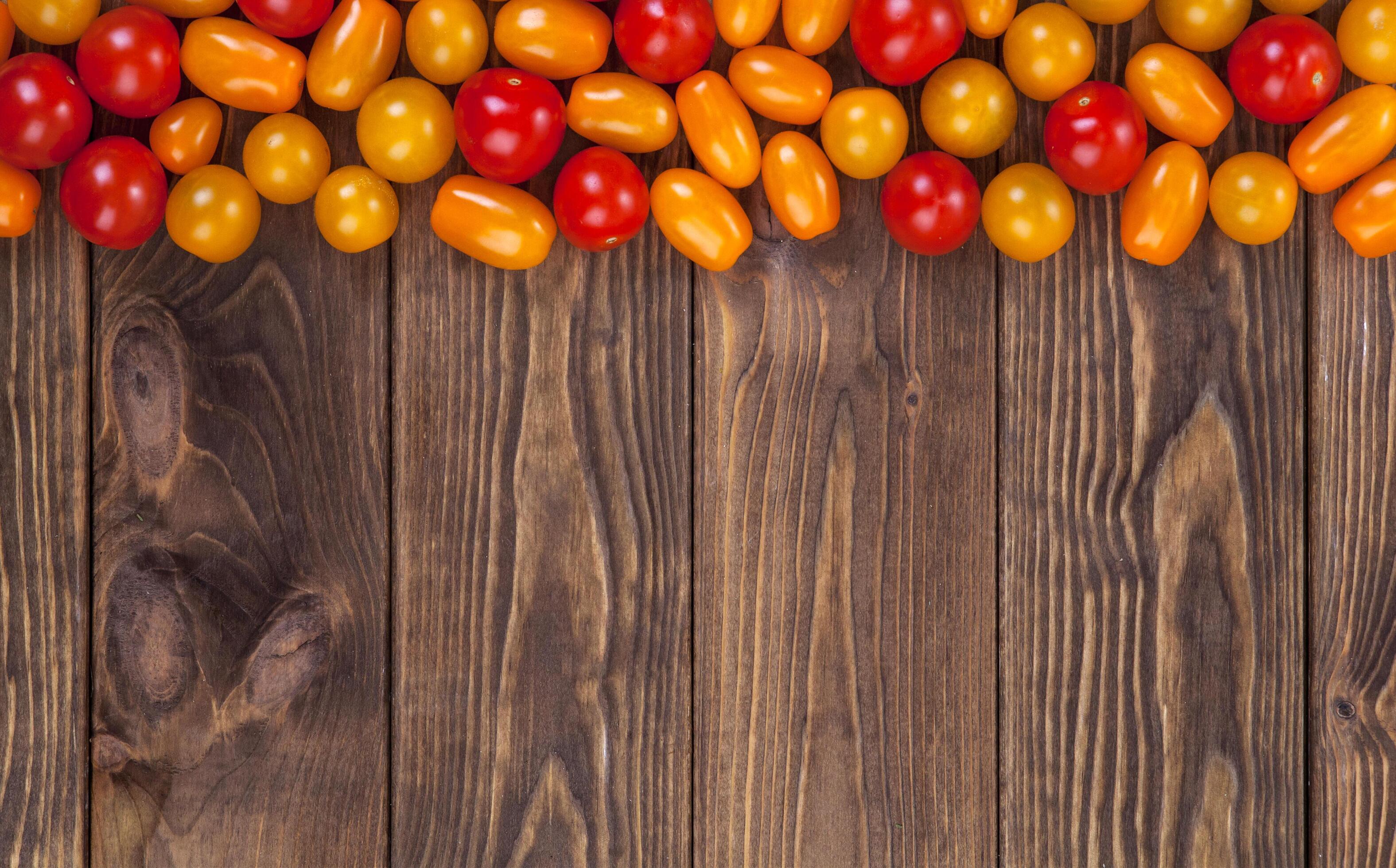 Cherry tomatoes on wooden table background, top view Stock Free