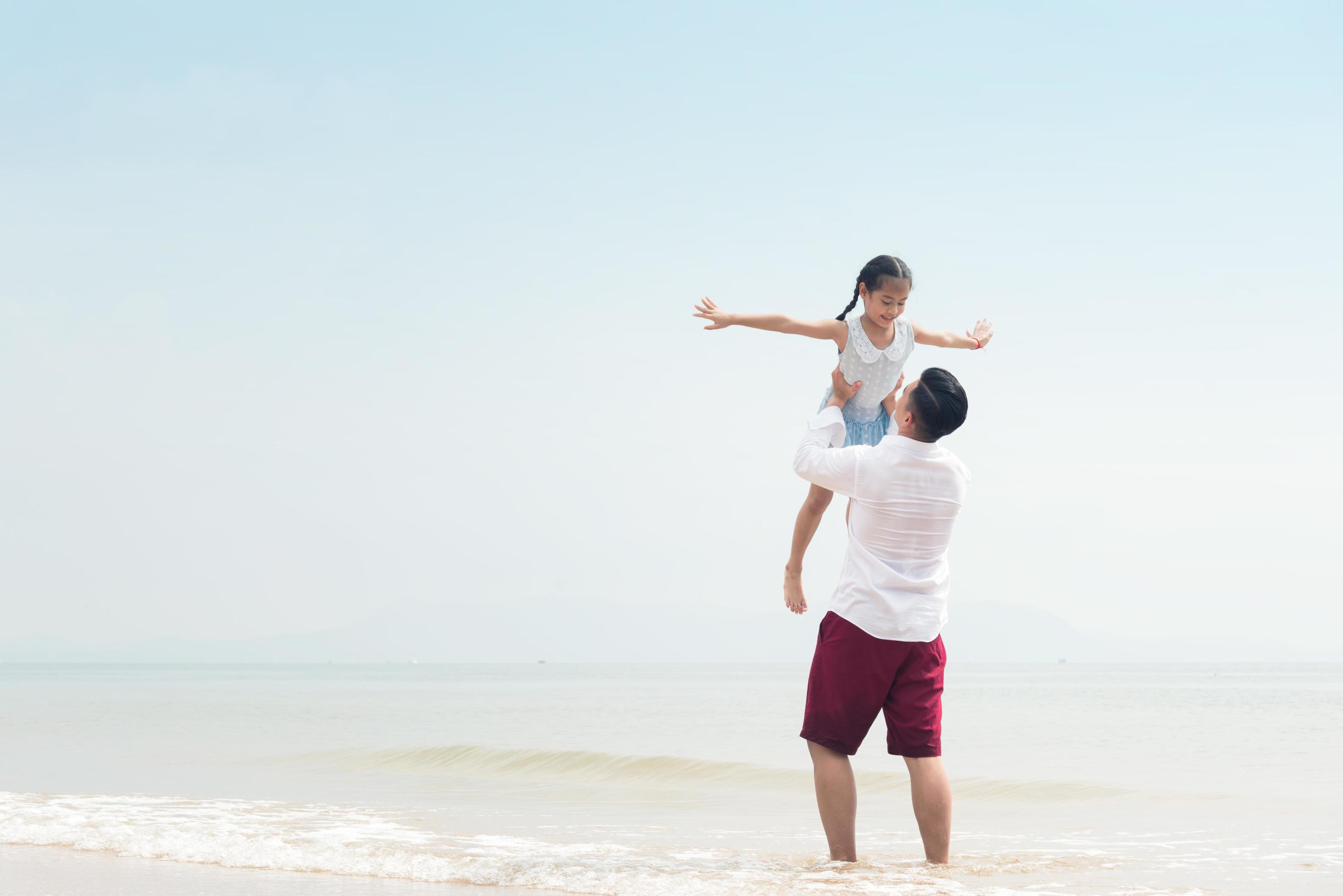 Happy family on beach run and jump at sunset Stock Free