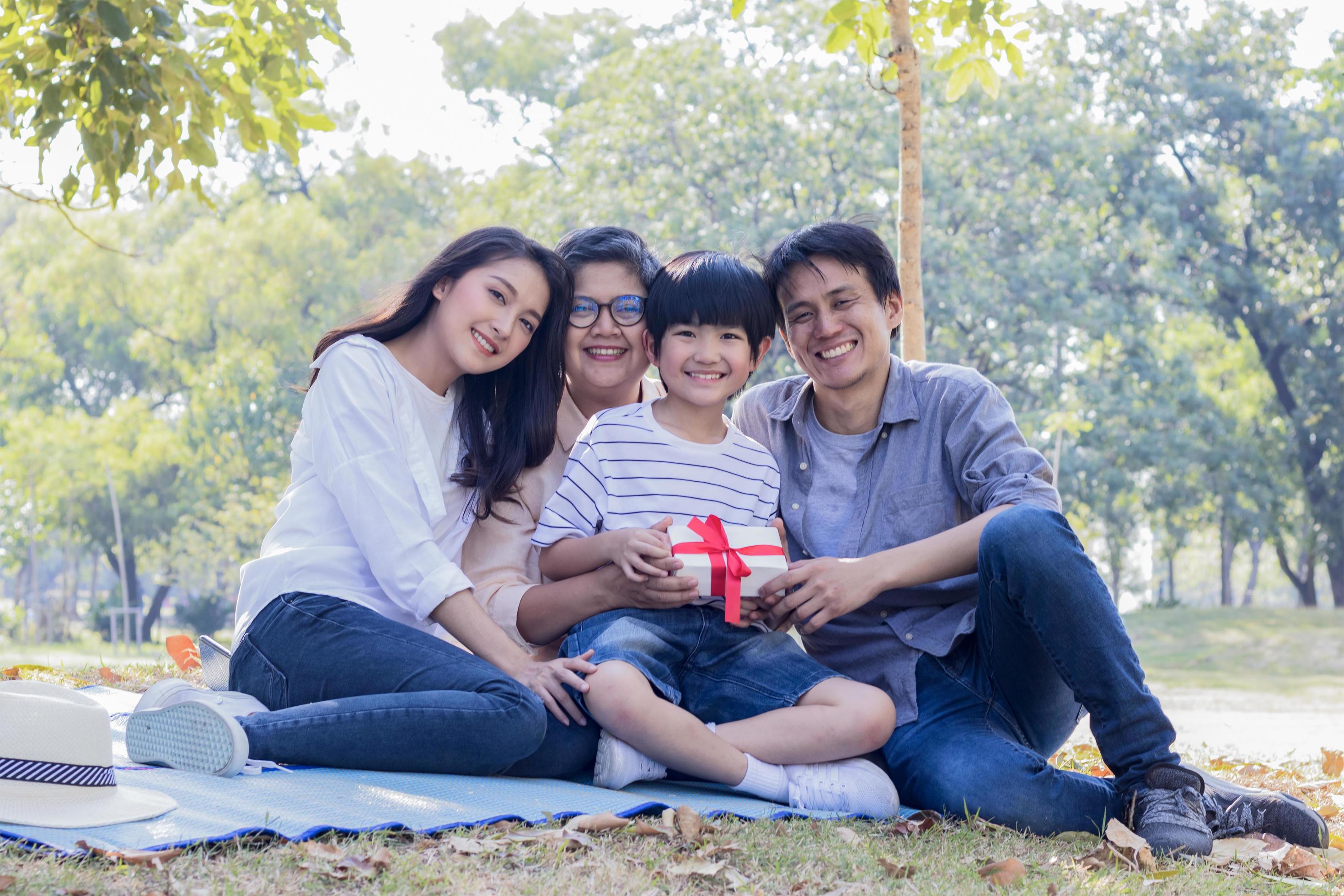 Asian family enjoys sitting in the park on the autumn holiday. Stock Free