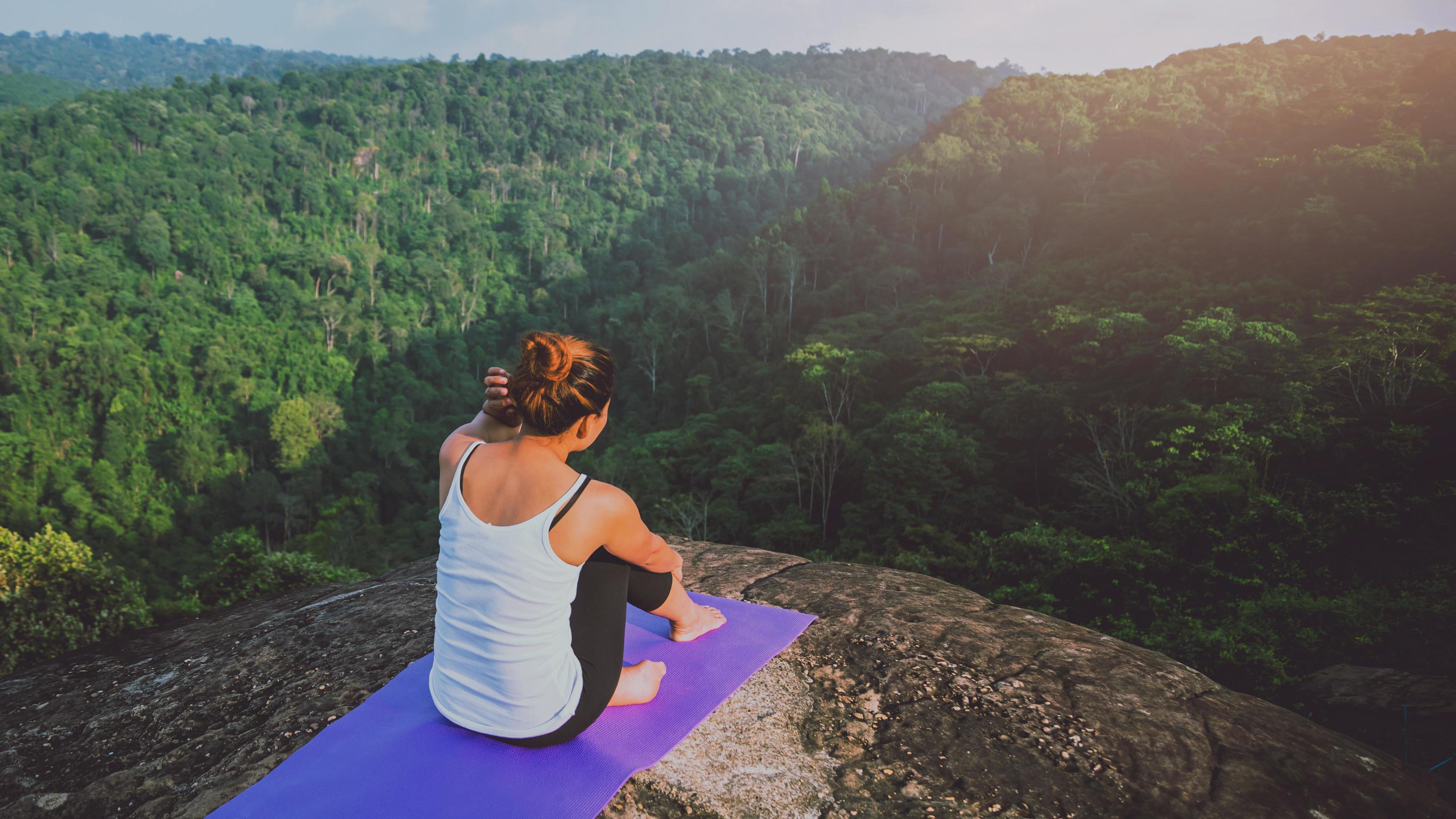 Asian women relax in the holiday. Play if yoga. On the Moutain rock cliff. Nature of mountain forests in Thailand Stock Free