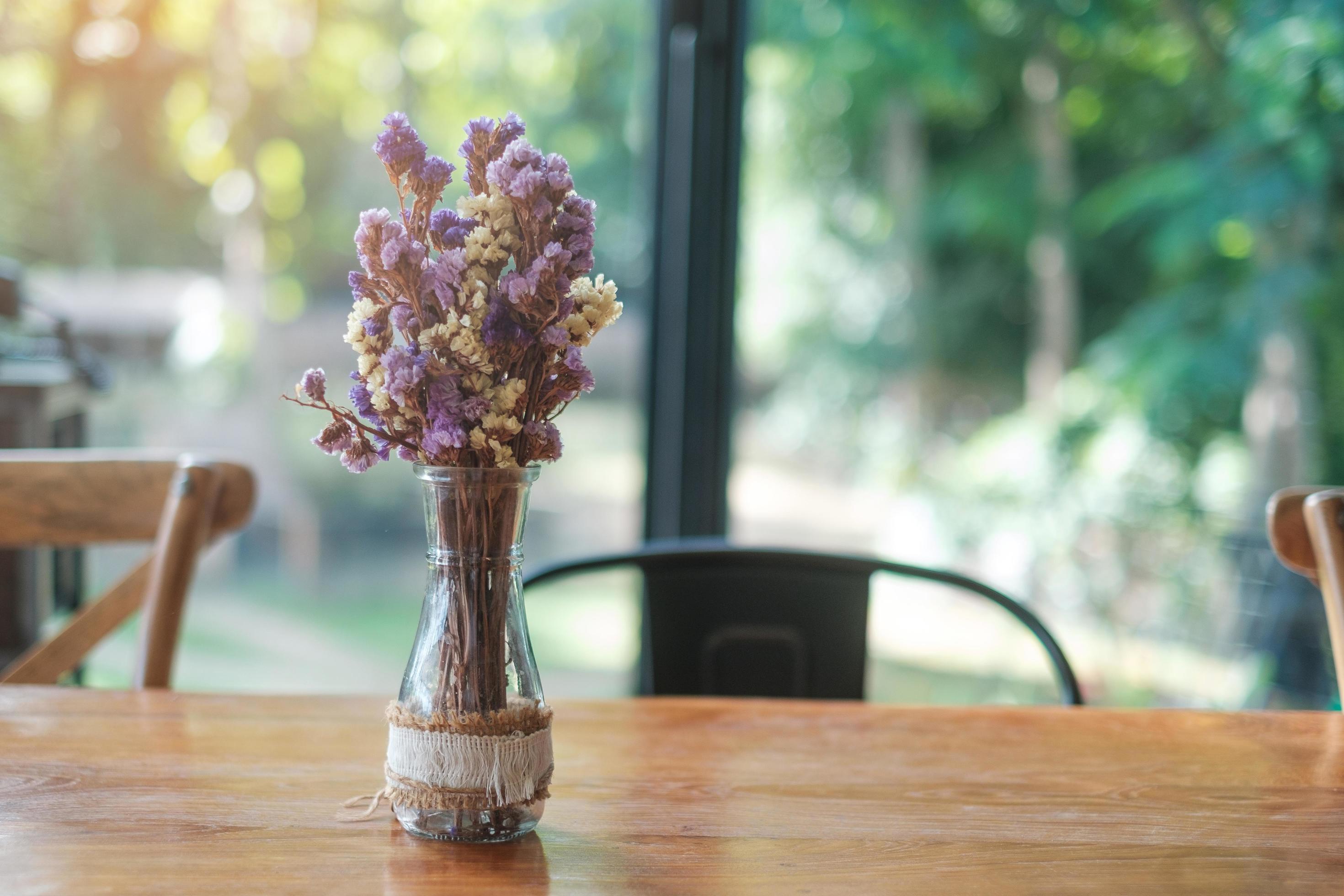 Beautiful Dried statice or Sea Lavender flower Limonium spp. in glass jar on wooden table. for background with blank copy space Stock Free