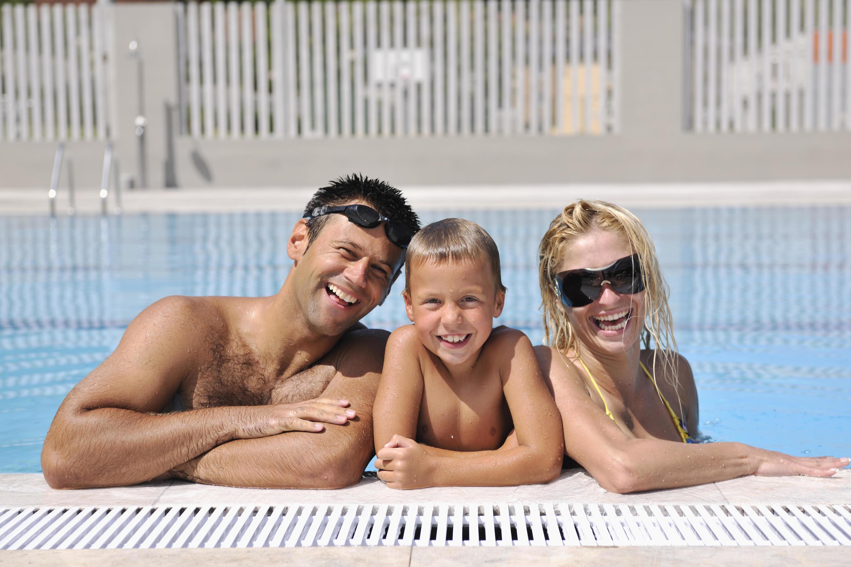 happy young family have fun on swimming pool Stock Free