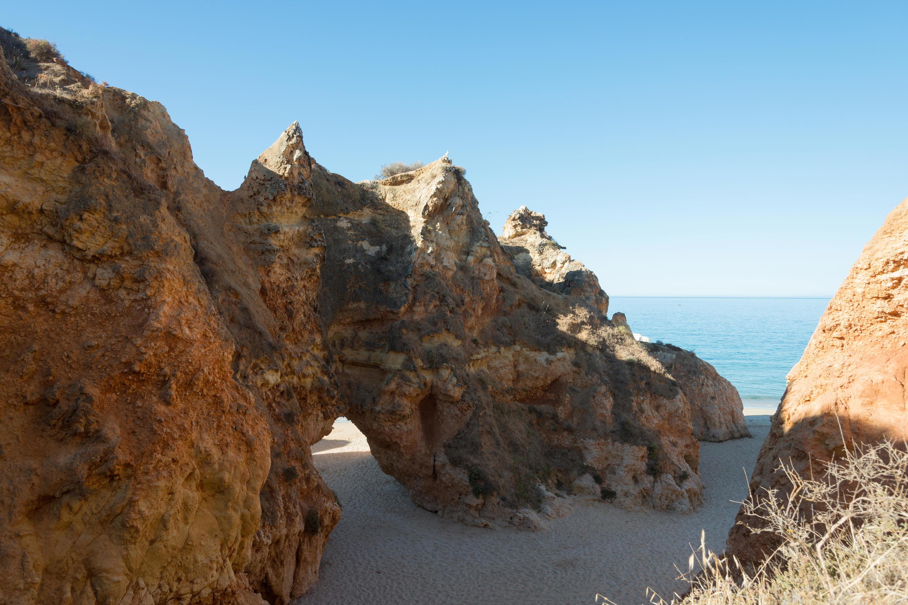 Beautiful natural limestone arch on a beach. Blue ocean in the background. Alvor, Portugal Stock Free