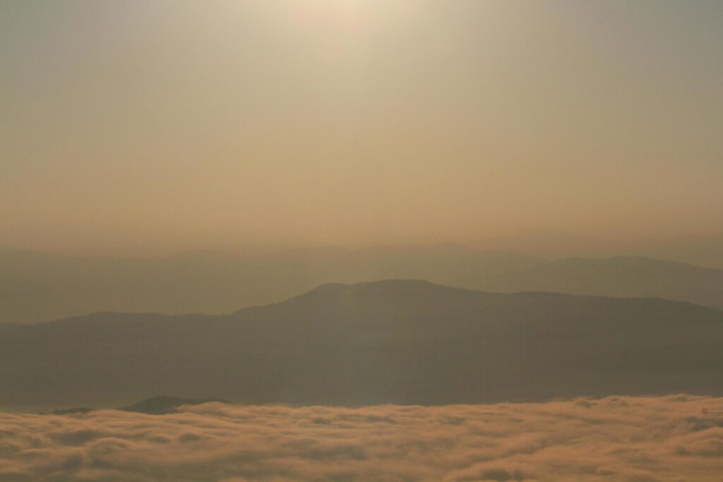 Beautiful golden natural sunlight and twiligh of sunrise shining to in the mist on valley of mountain in Thailand Stock Free