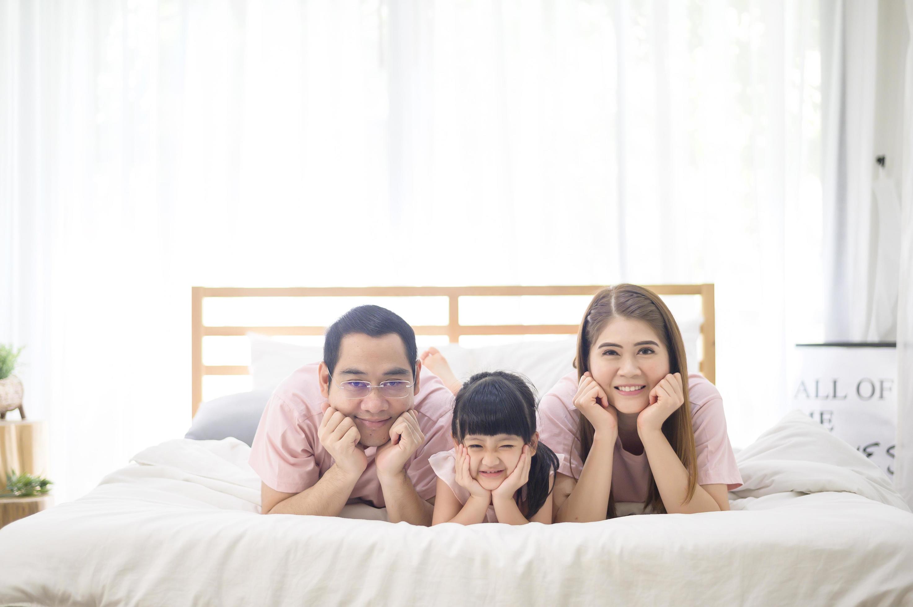 portrait of happy Asian family in white bedroom Stock Free