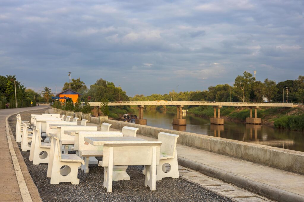 Views of rows of white marble tables and chairs are laid out on a paved stone floor, paving a way. Stock Free