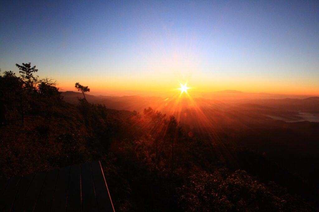 Beautiful golden natural sunlight and twiligh of sunrise shining to in the mist on valley of mountain in Thailand Stock Free