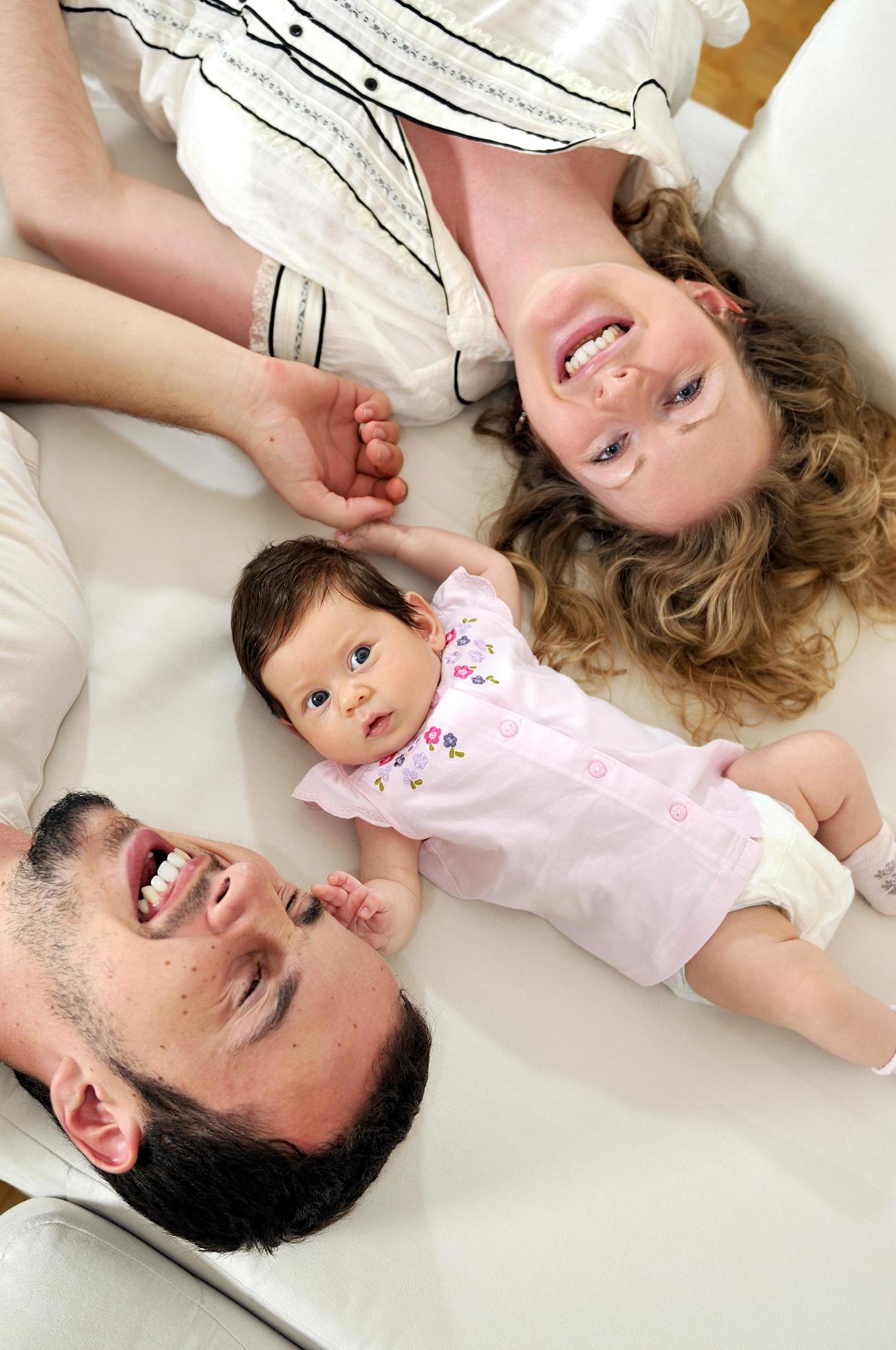 indoor portrait with happy young family and cute little babby Stock Free