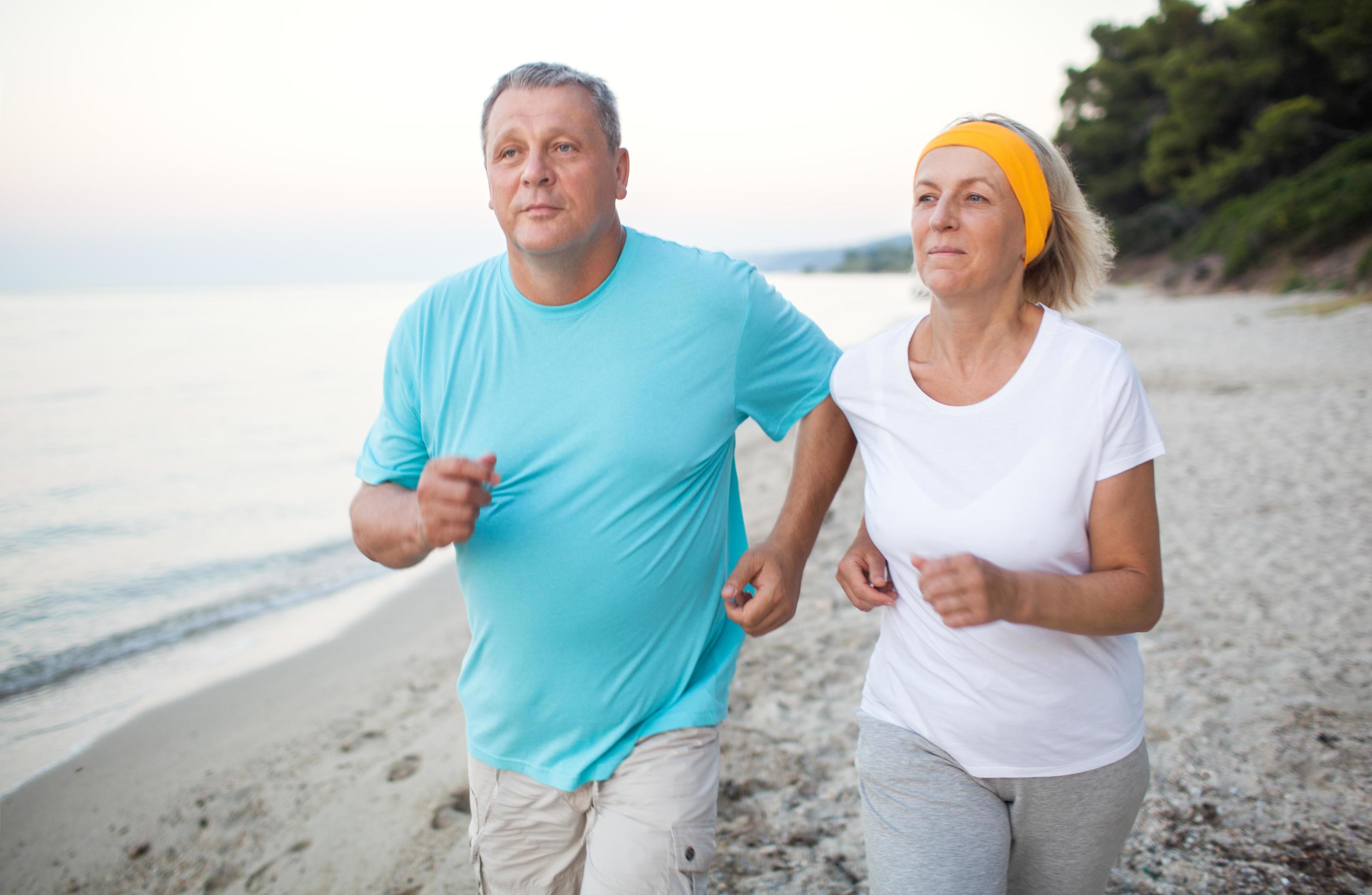 Senior couple jogging on the beach Stock Free