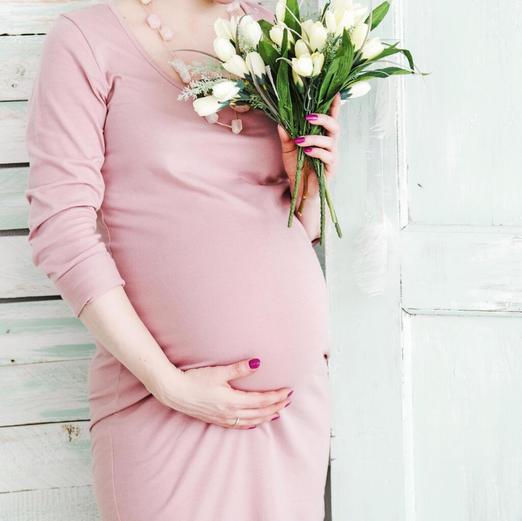 Pregnant woman holding white flowers Stock Free