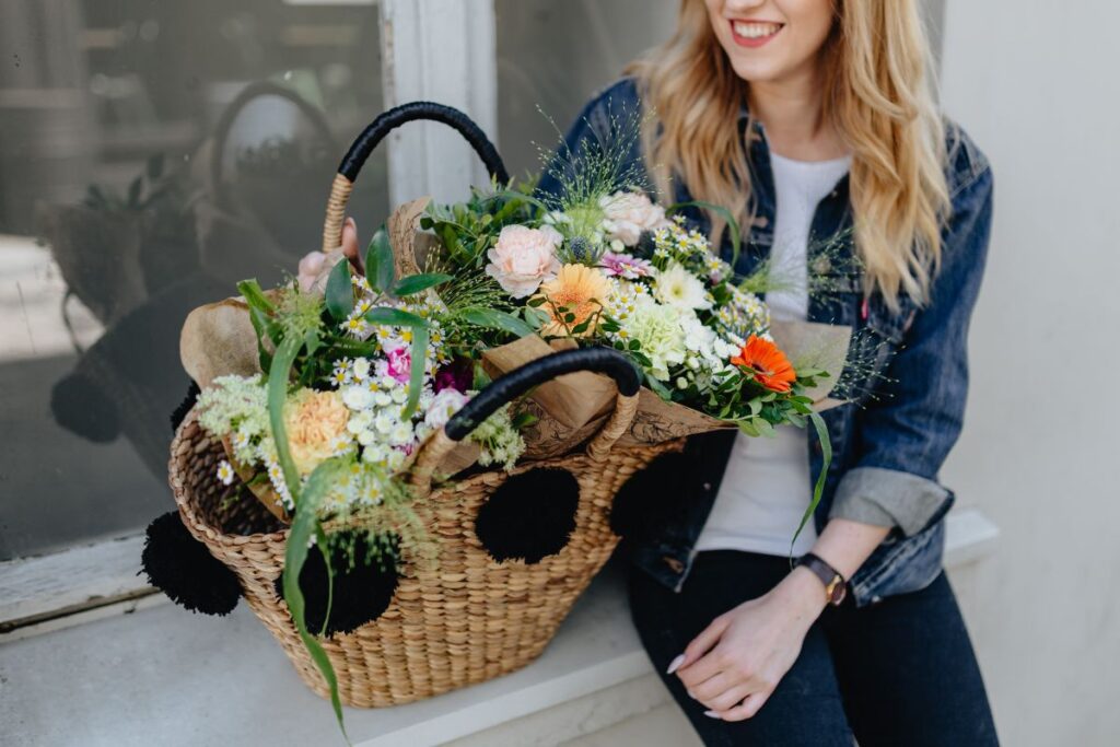 Young woman with basket full of flowers Stock Free