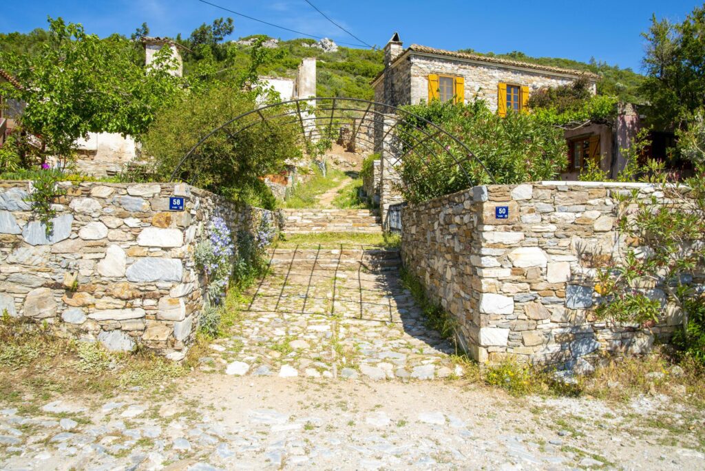 Stone Turkish fence next to the house on a sunny and summer day. Stock Free