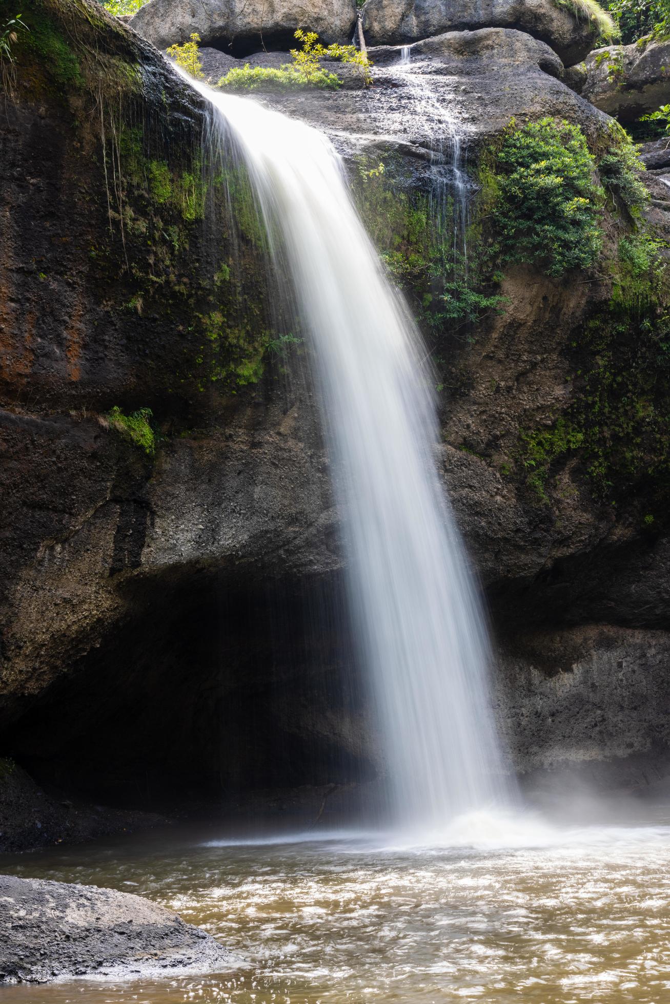 A natural waterfall in a big forest in the midst of beautiful nature. Stock Free