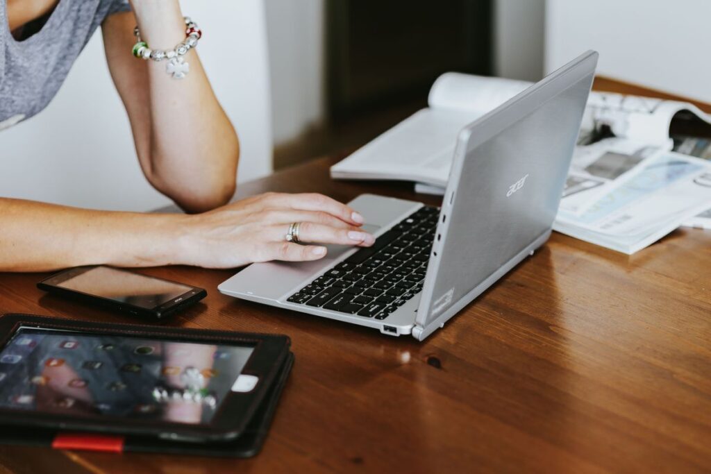 Silver laptop with various items on a table Stock Free