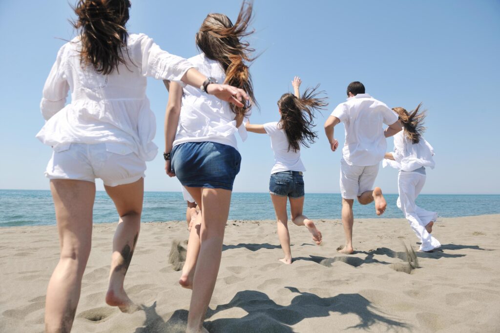 happy people group have fun and running on beach Stock Free