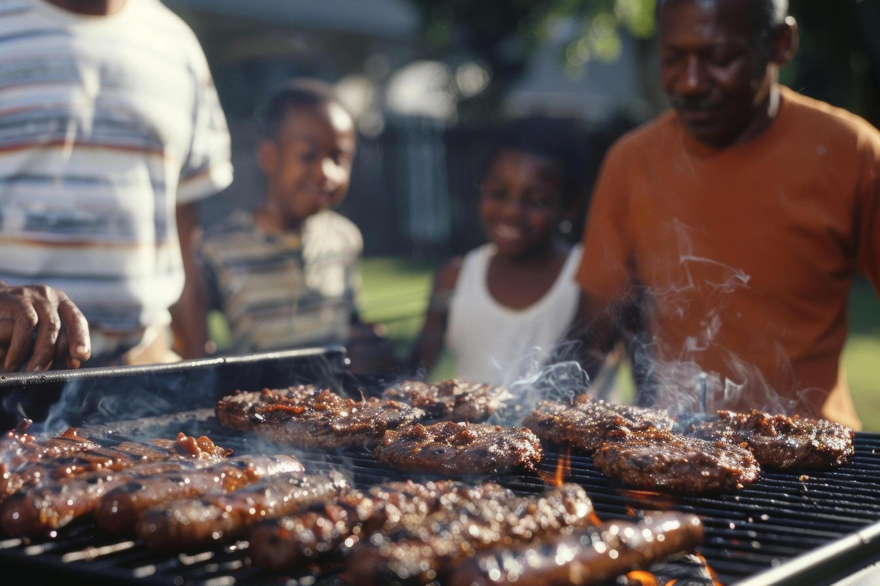 A family gathered around a barbecue grill in a backyard, cooking burgers and hotdogs Stock Free